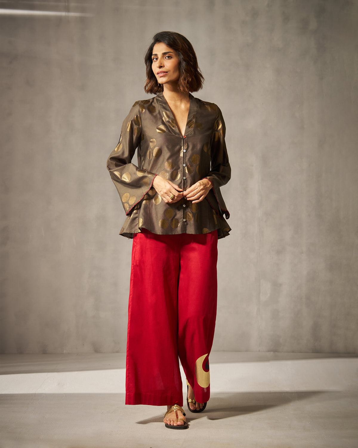 Person wearing red Basic pyjamas with a gold circle motif.