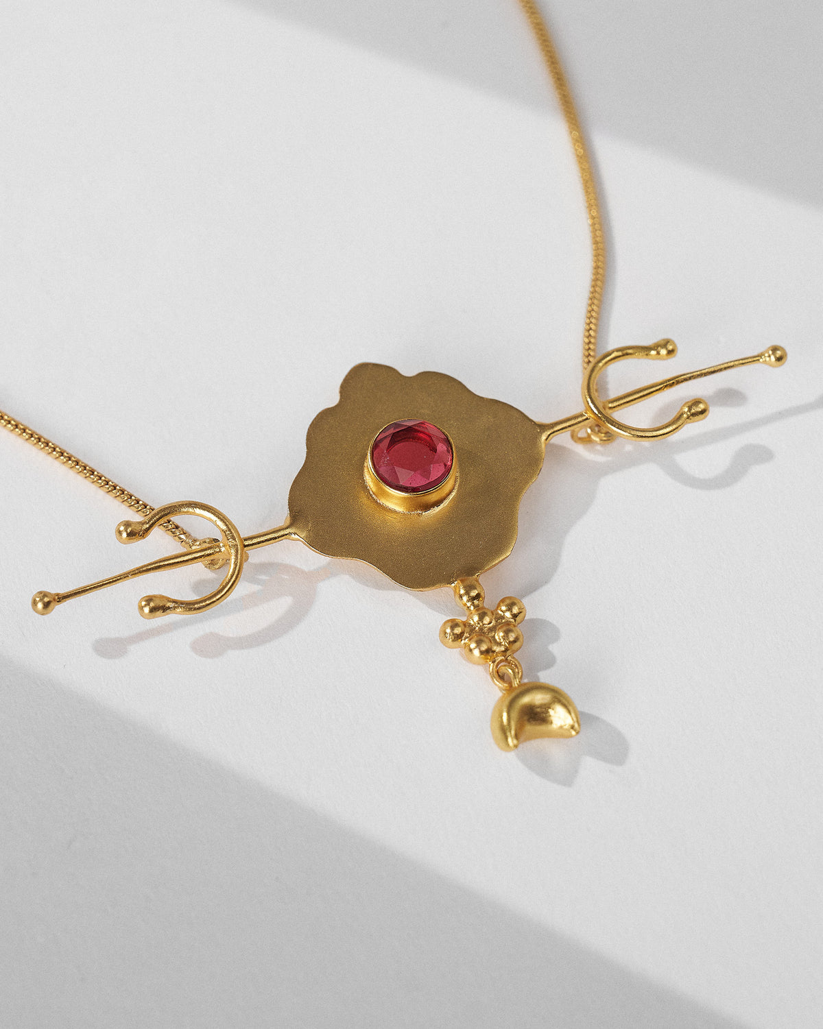 Close-up of Berber necklace red glass pendant with a crescent charm.