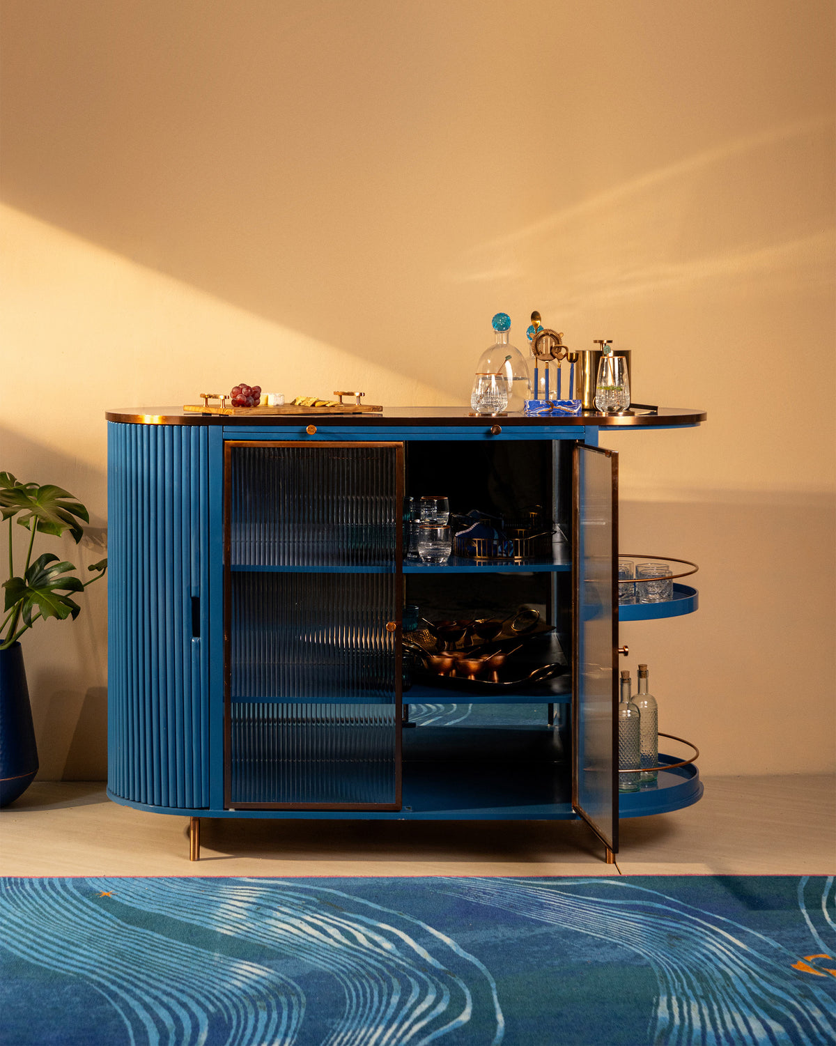 Contours of Time cabinet styled as a bar with glassware on open shelves.