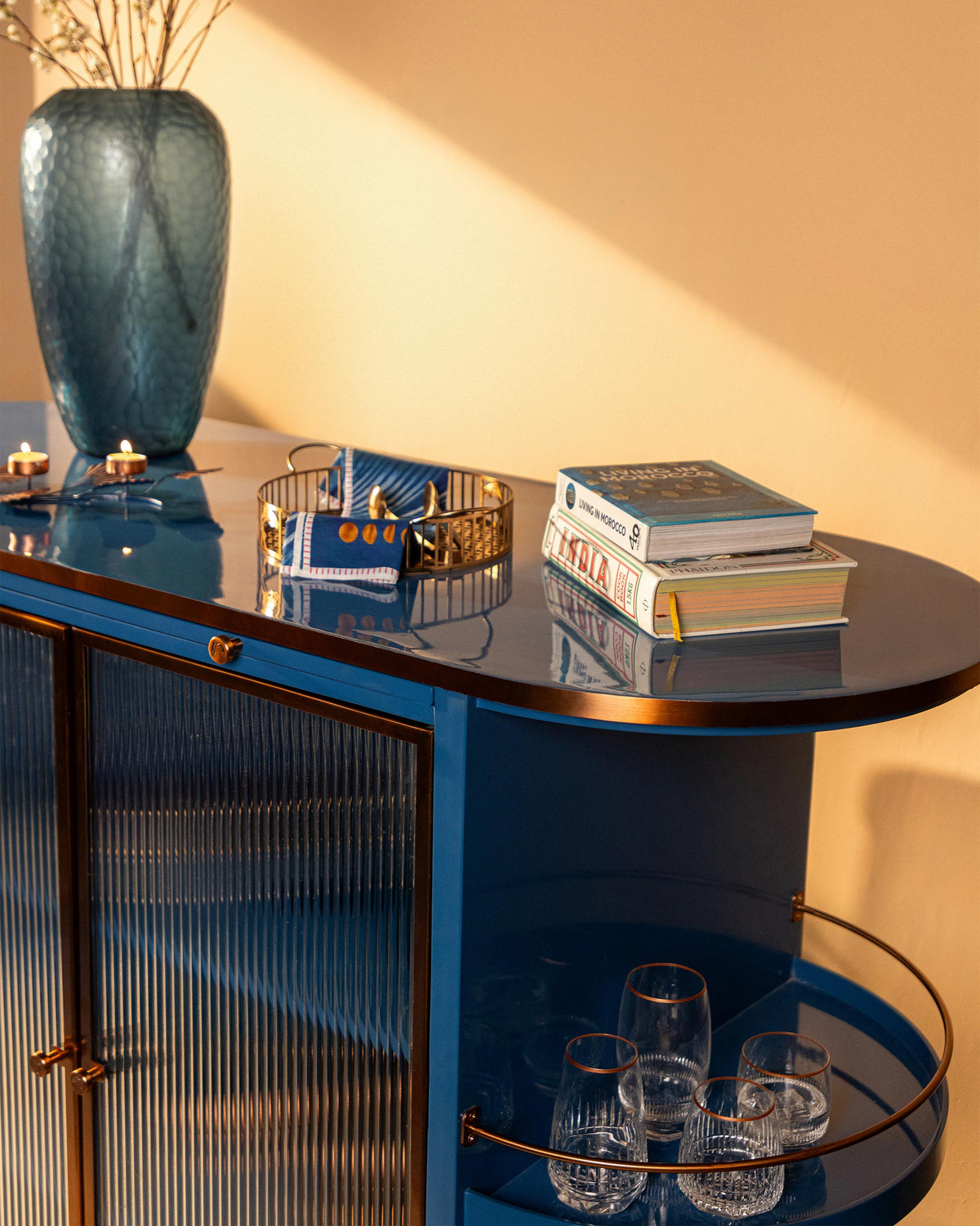 Overhead Contours of Time cabinet top with copper rim and glasses on the side shelf.