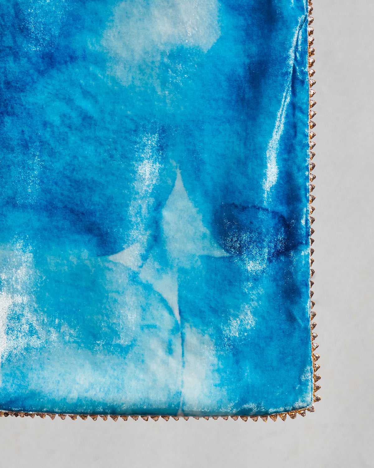 Close-up of Pacific throw corner showing its blue pattern and edge stitching.