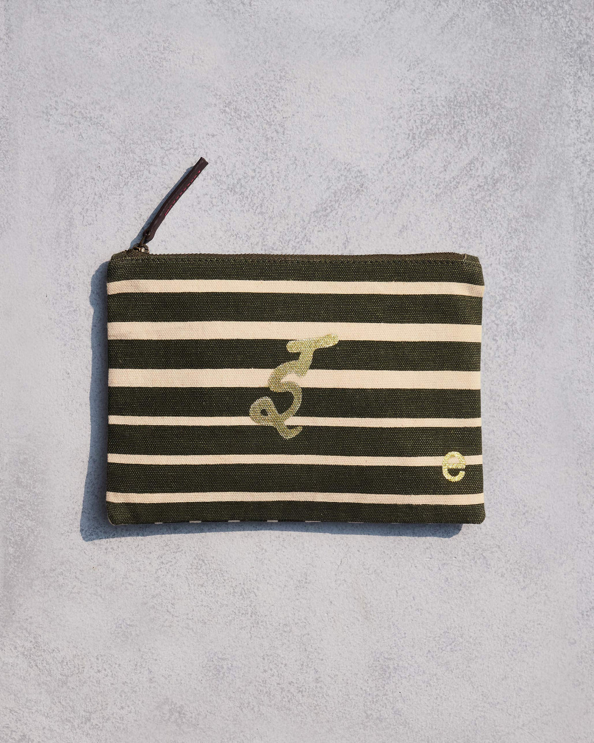 Alphabet E Pouch in olive and cream stripes with a gold letter.