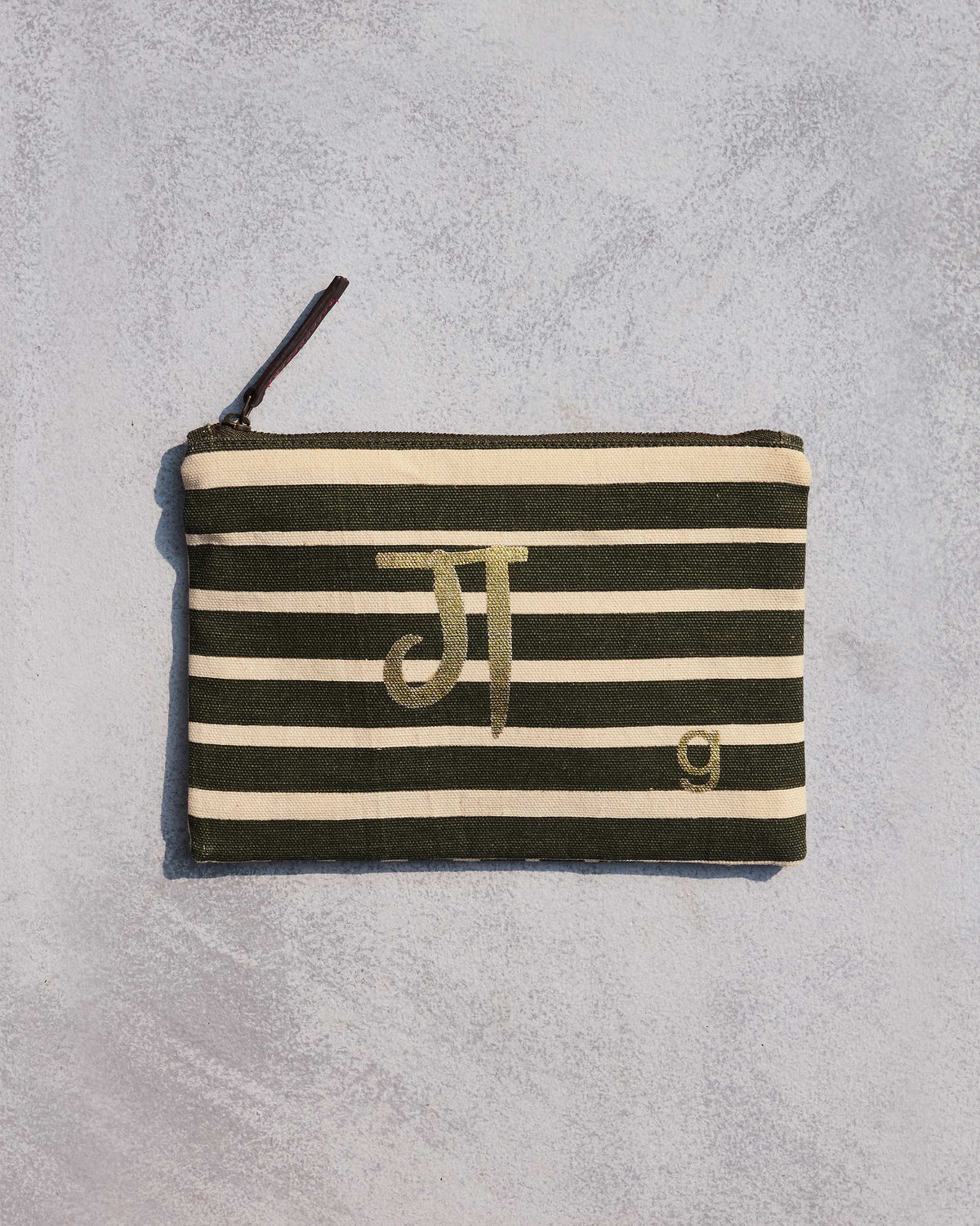 Alphabet G Pouch in olive and cream stripes with a gold script letter.