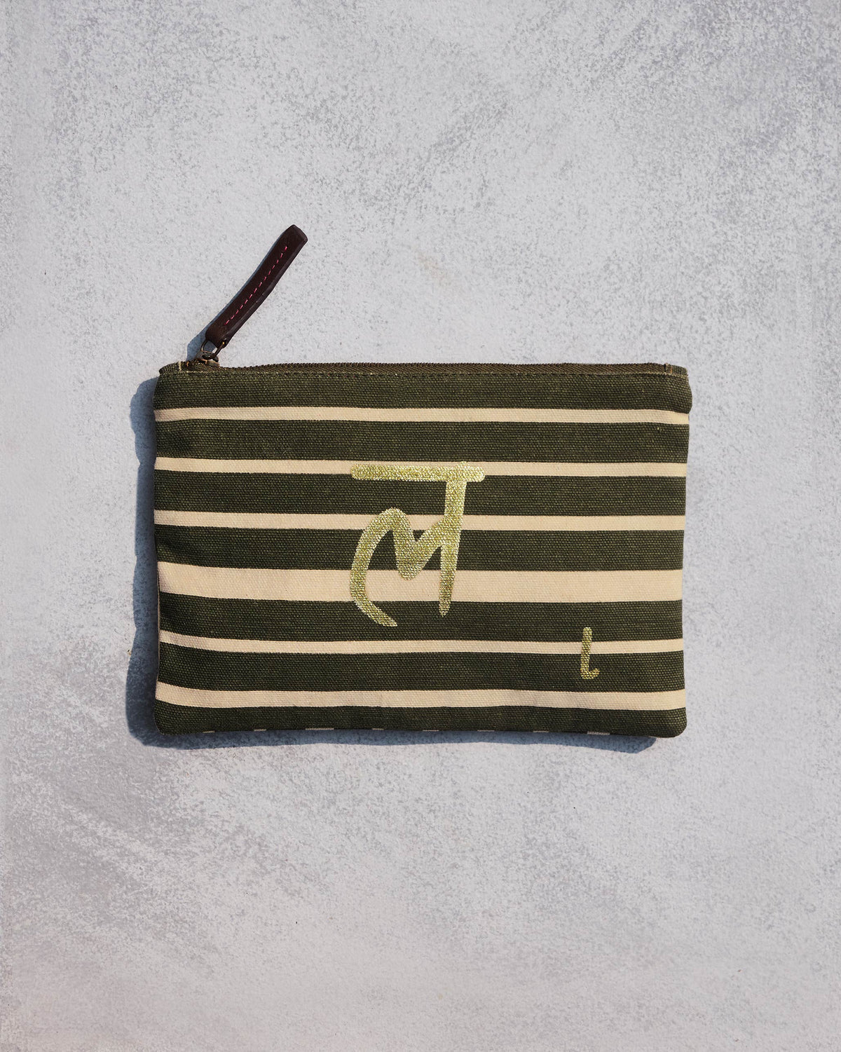 Alphabet L Pouch in olive and cream stripes with a gold script letter.