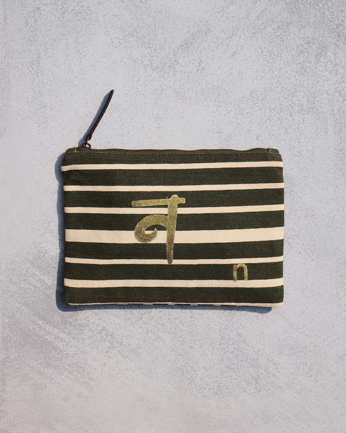 Alphabet N Pouch in olive and cream stripes with a gold script letter.