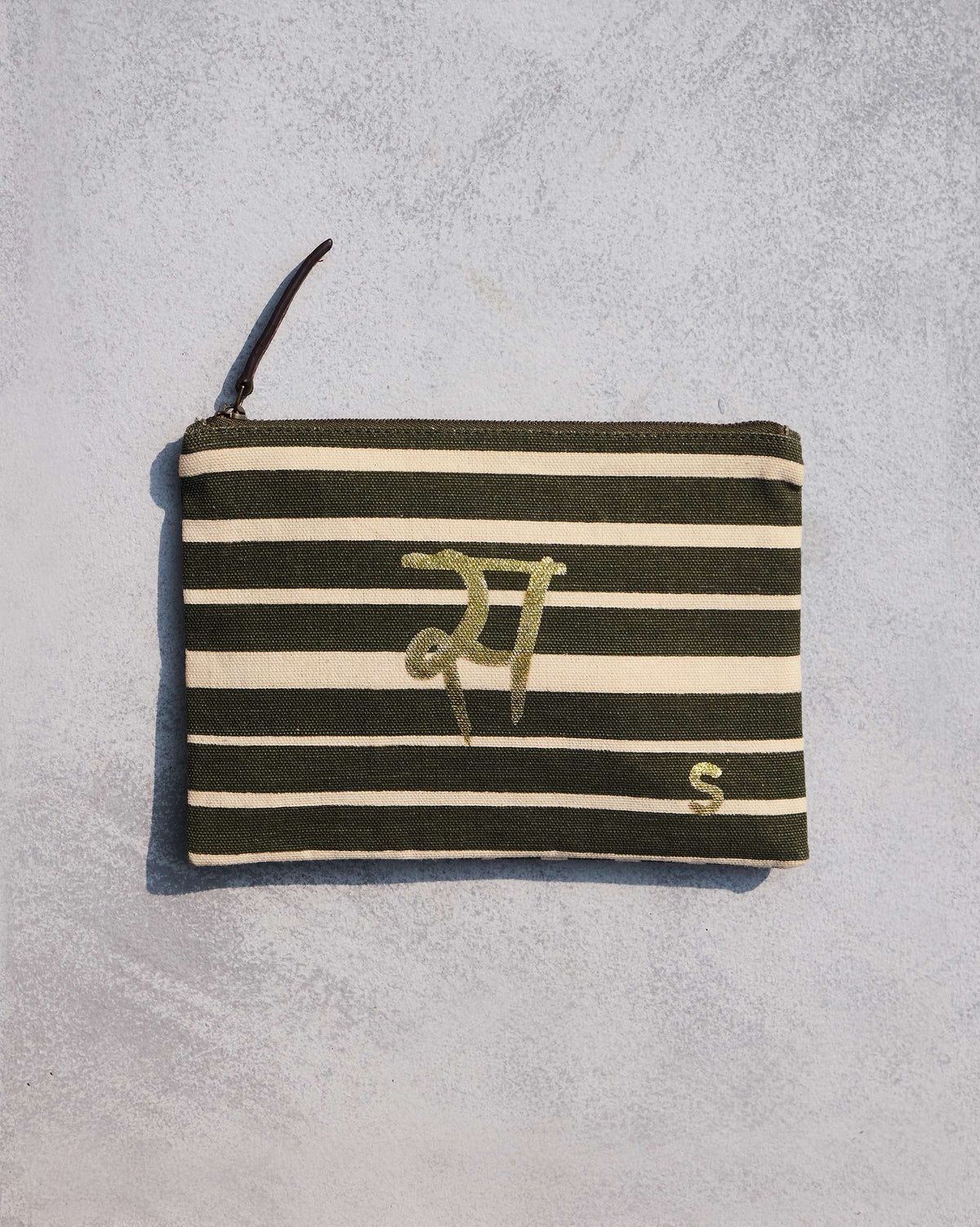 Alphabet S Pouch in olive and cream stripes with a gold script letter.