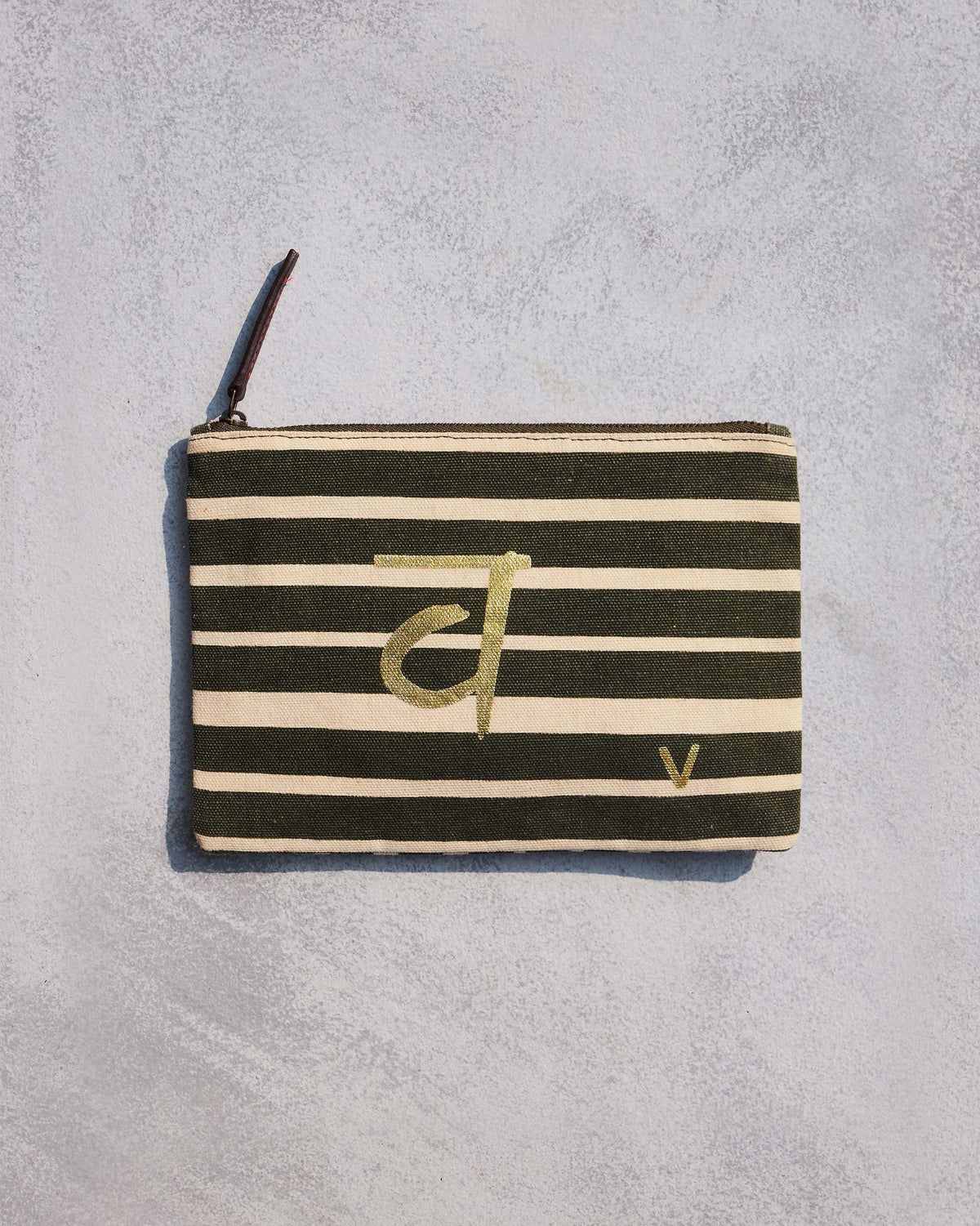 Alphabet V Pouch in olive and cream stripes with a gold script letter.