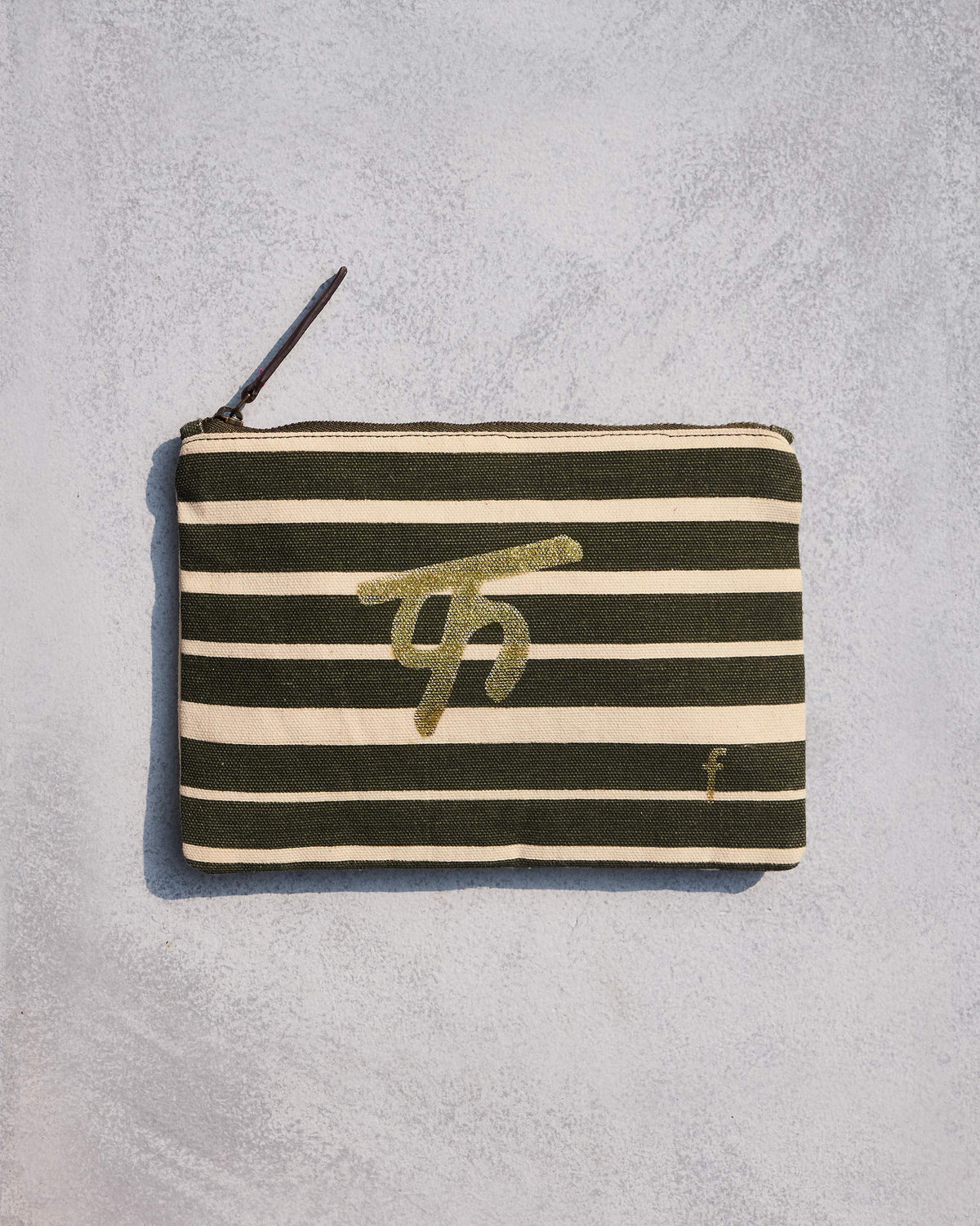 Olive and cream striped Alphabet F Pouch with a gold letter motif.