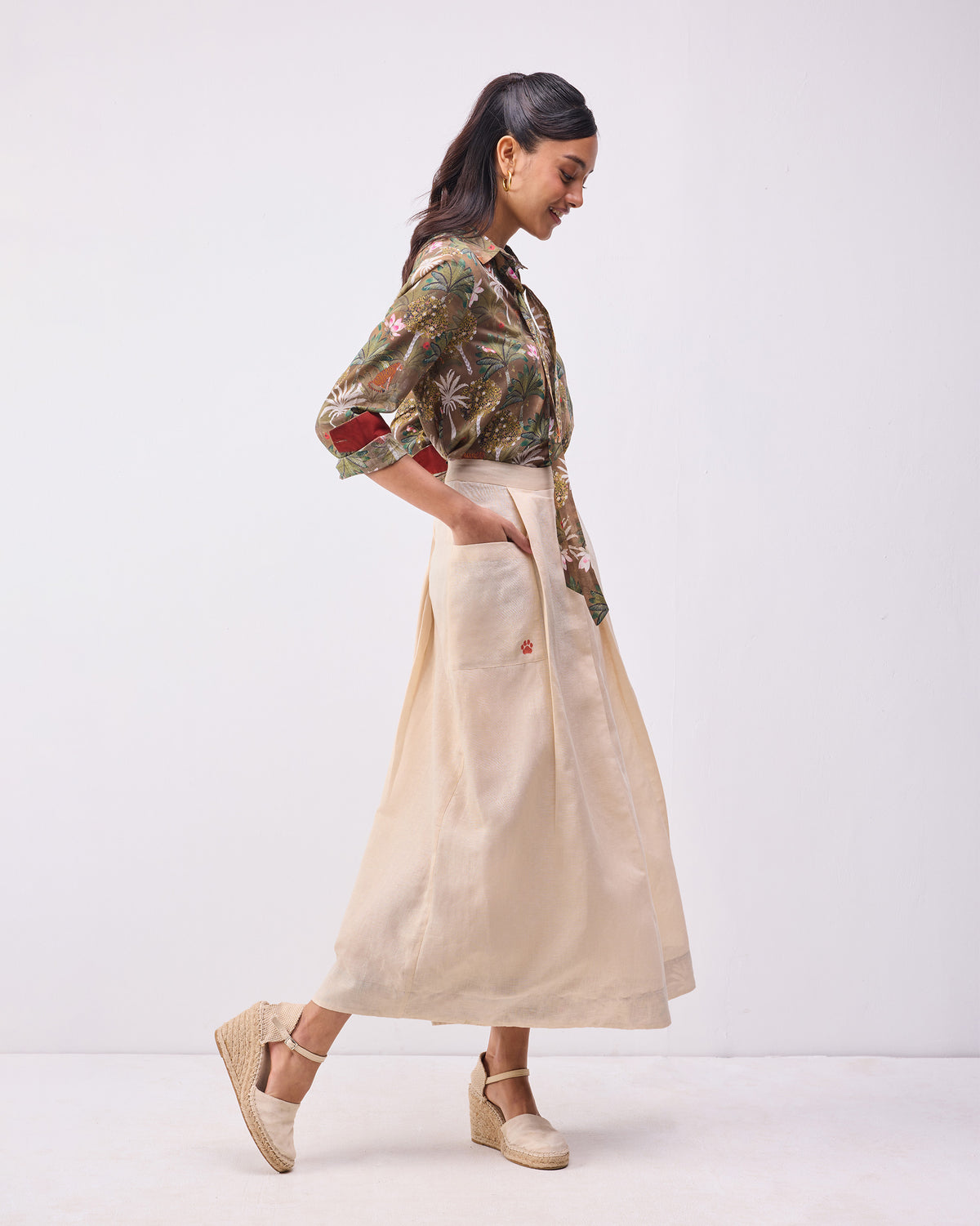 Side view of a beige Pocket skort with a patch pocket.