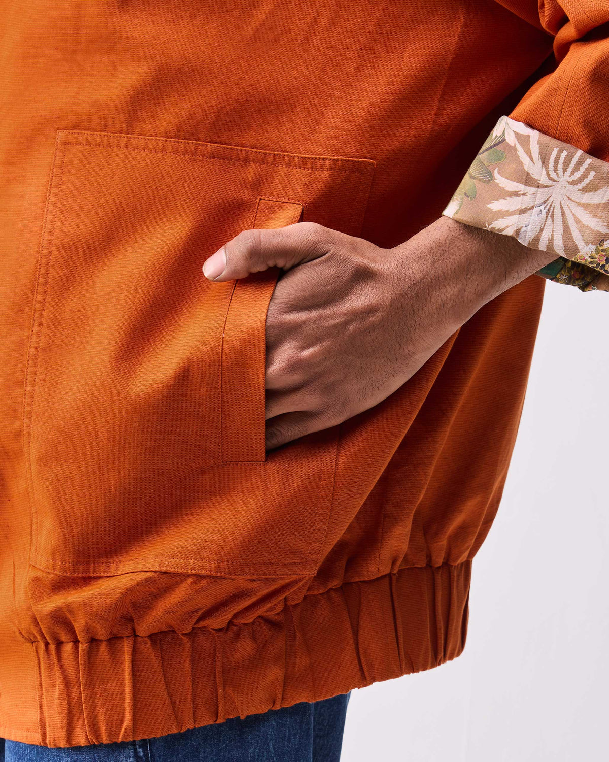 Close-up of a rust Safar bomber pocket and botanical cuff lining.