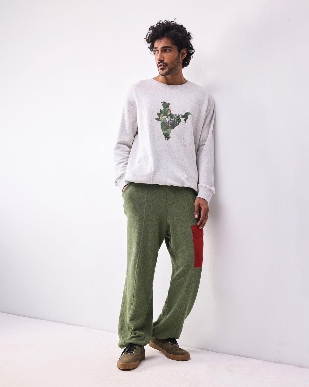 Person wearing green Lounge Pants with centre leg seams and a red thigh pocket.