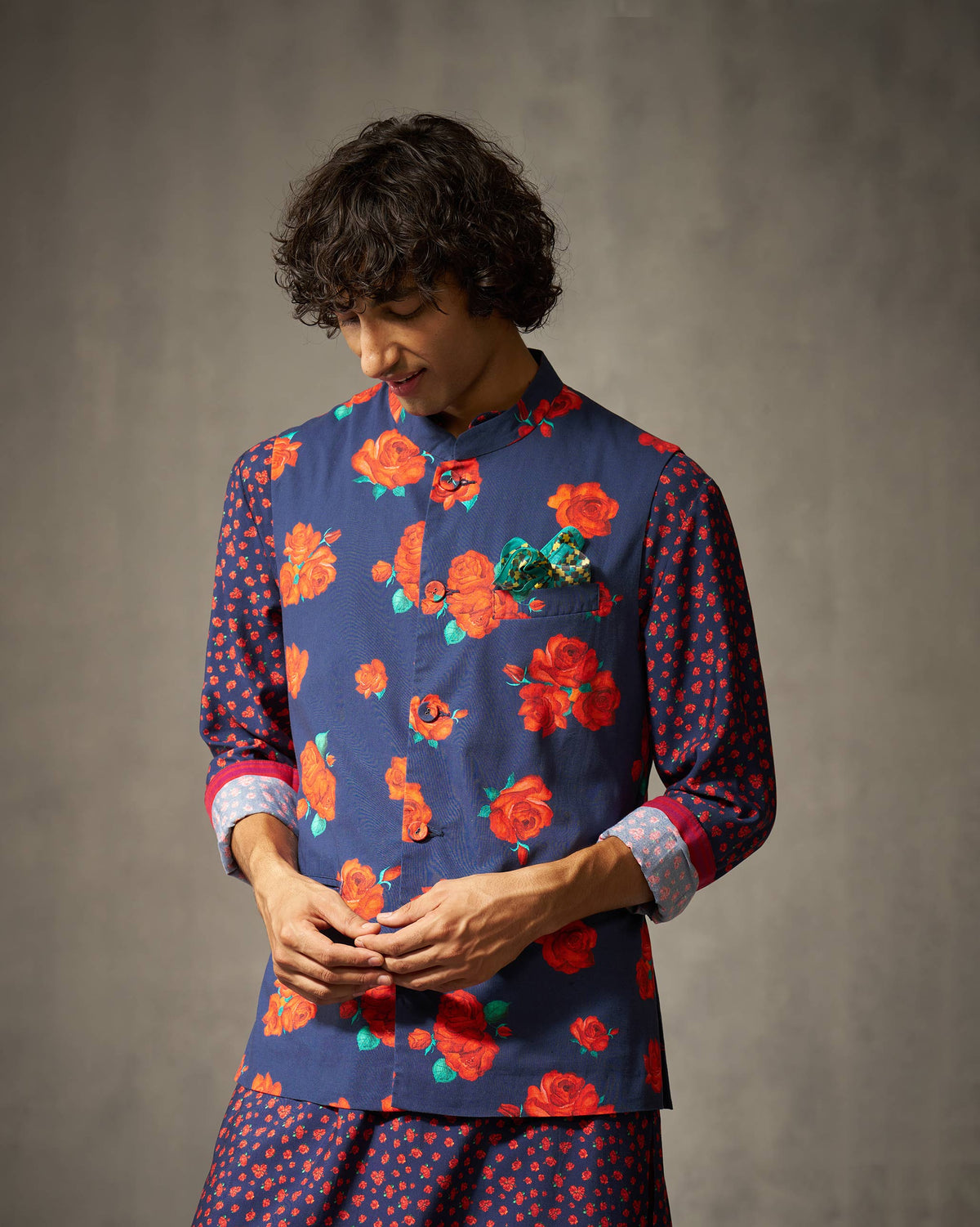 Person wearing a navy Nehru jacket with a red rose print.