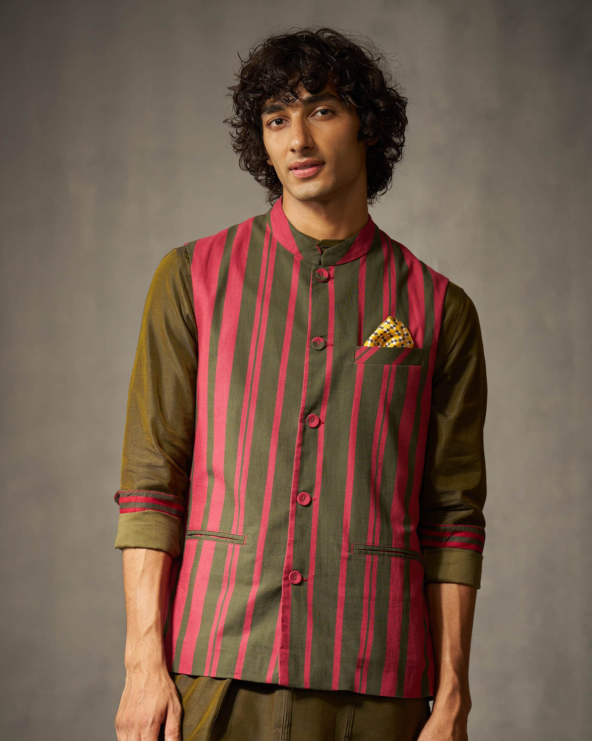 Person wearing a red and oak brown striped Nehru jacket with button placket.