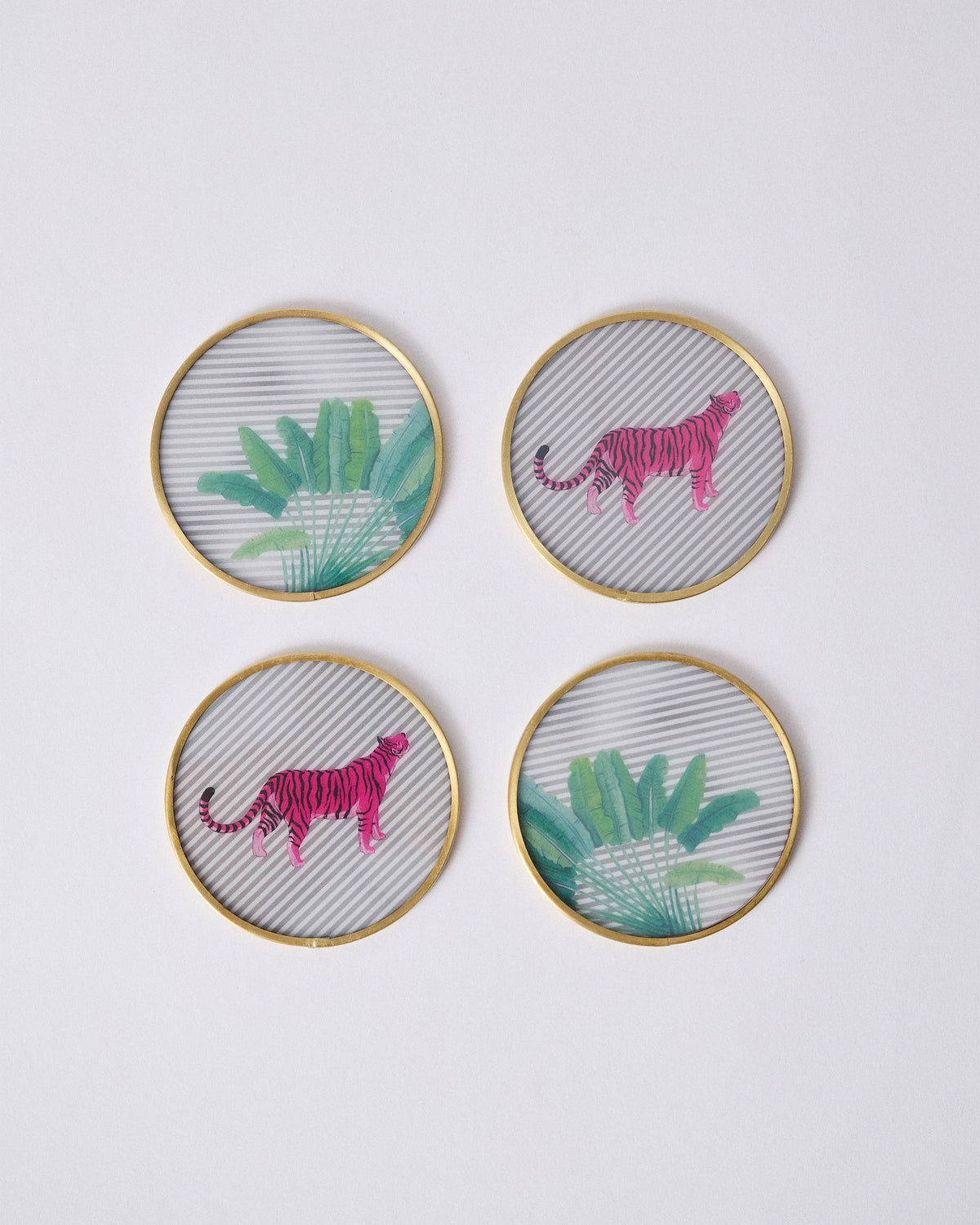 Set of four Ceylon Trail coasters with pink tigers and green leaves in brass rims.