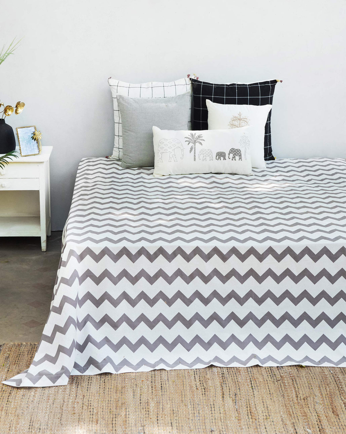 Grey and white Colombo Wave bedsheet with a chevron pattern on a bed.