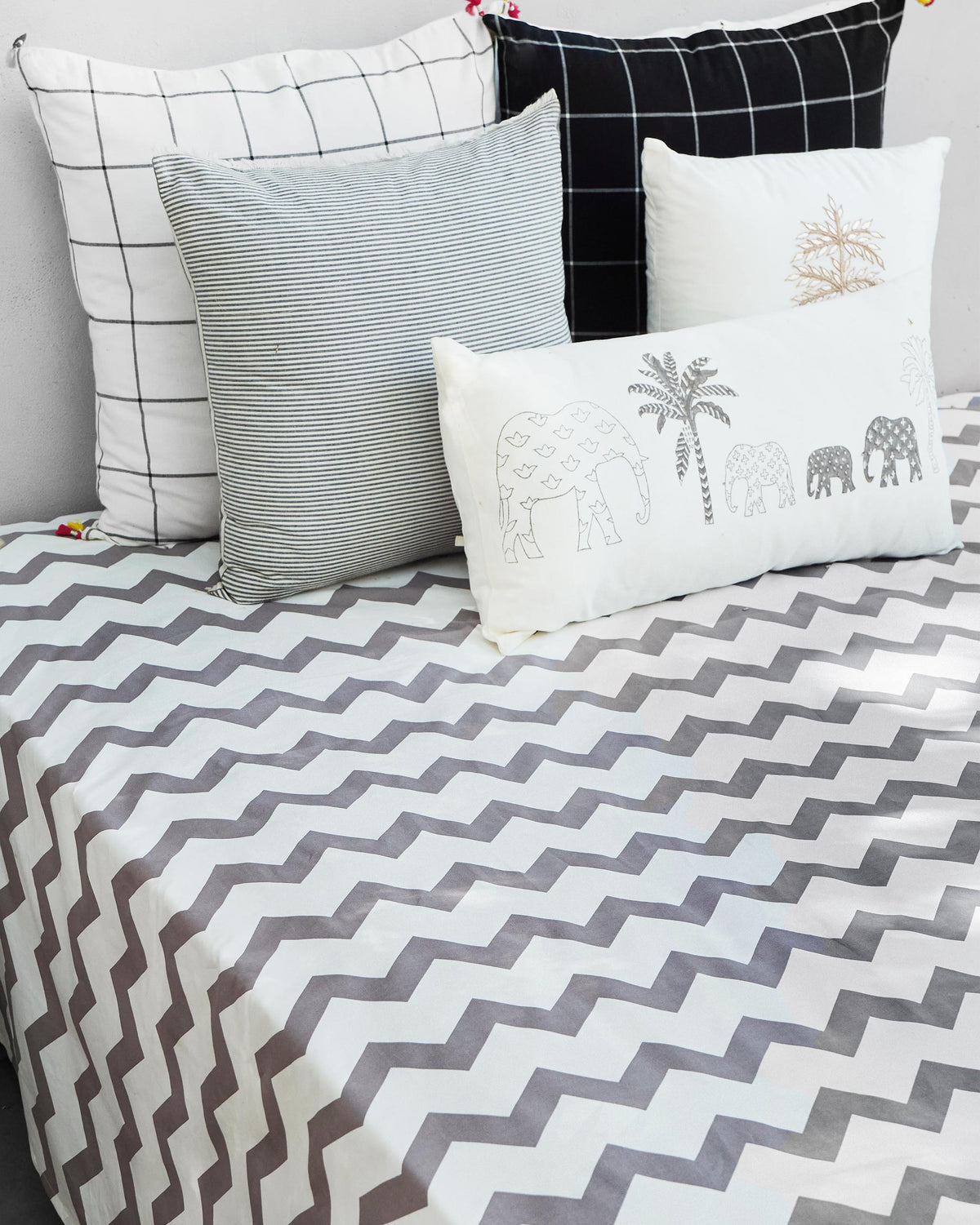 Grey and white Colombo Wave bedsheet with a chevron pattern on a bed.