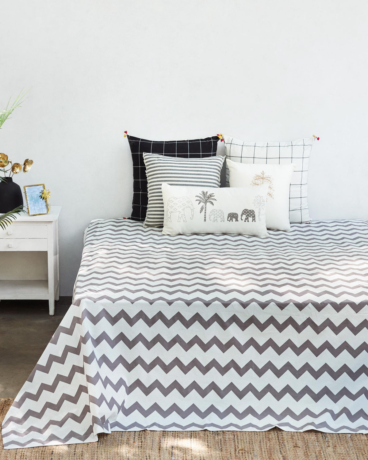 Grey and white Colombo Wave bedsheet with a chevron pattern on a bed.