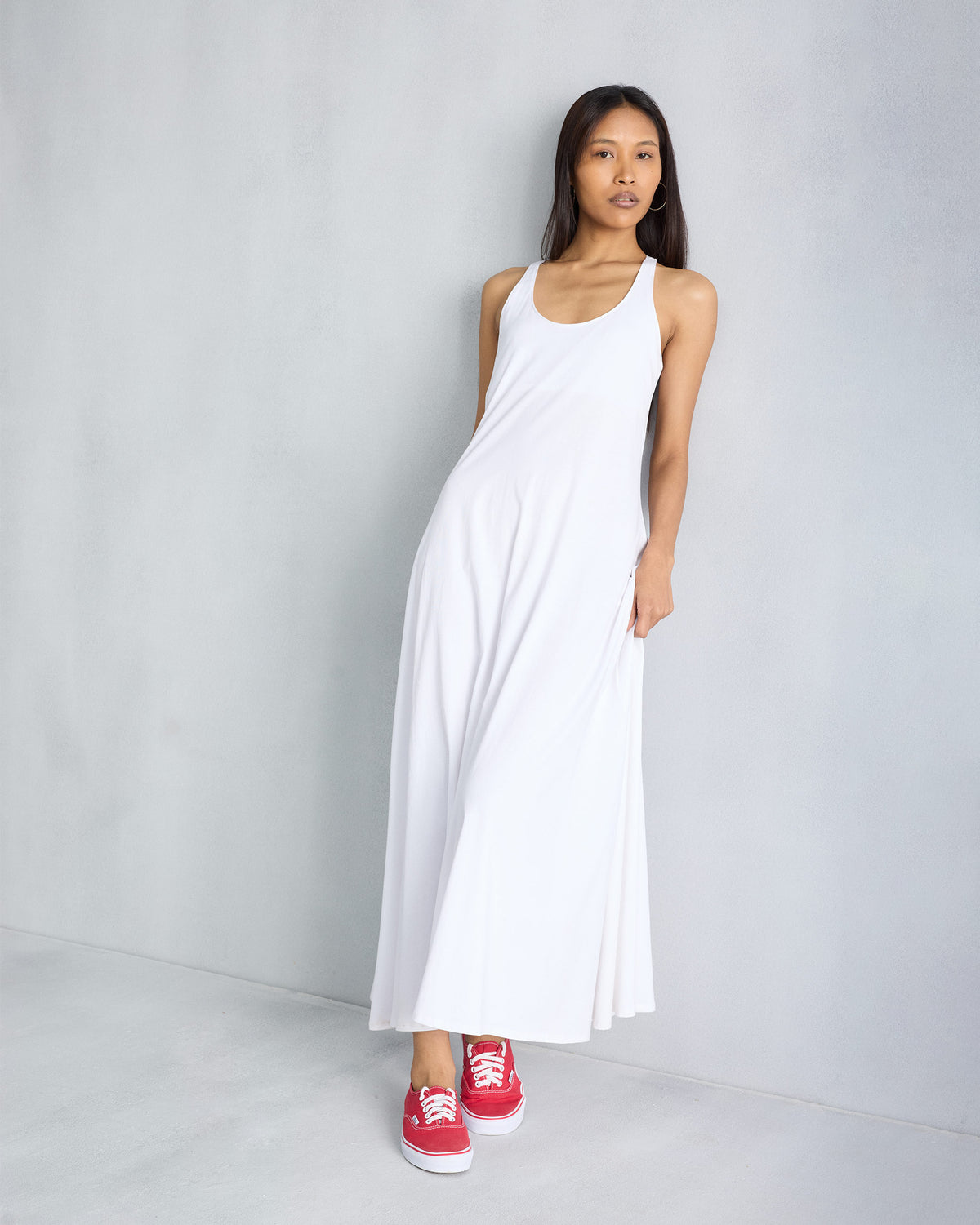 Person wearing a white sleeveless Esther dress with a scoop neck.