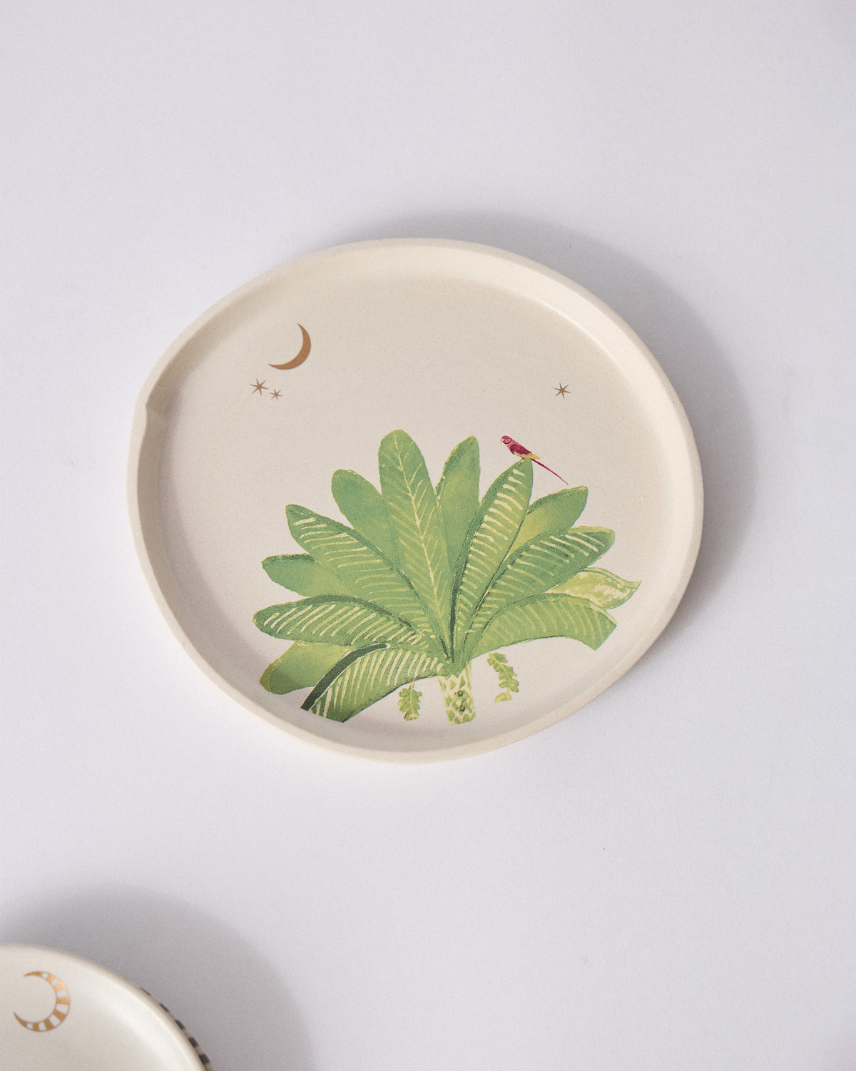 Ceylon Trail Dessert Plate with a palm plant, bird and crescent moon.