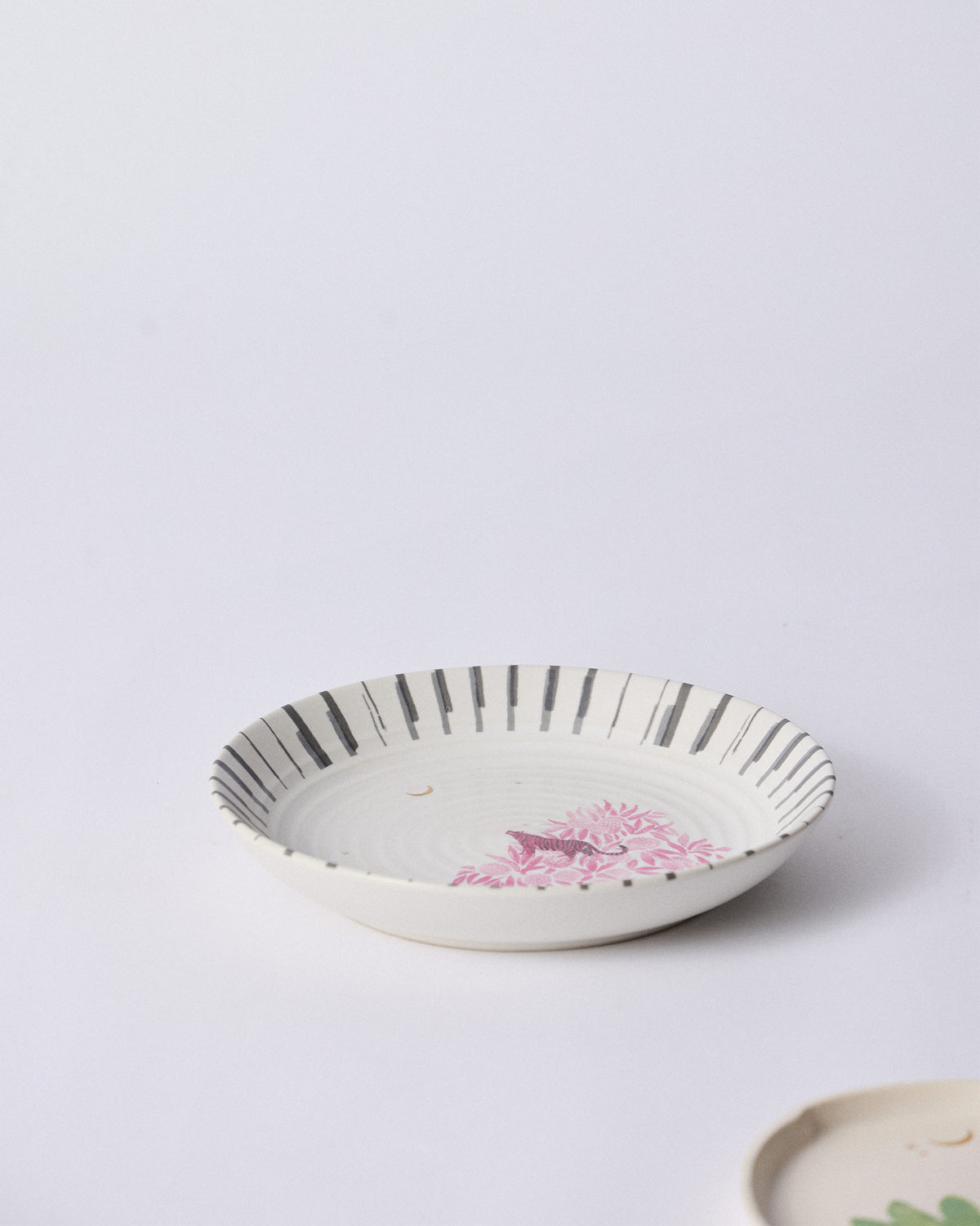 Ceylon Trail Pasta Plate with pink foliage on a striped rim.