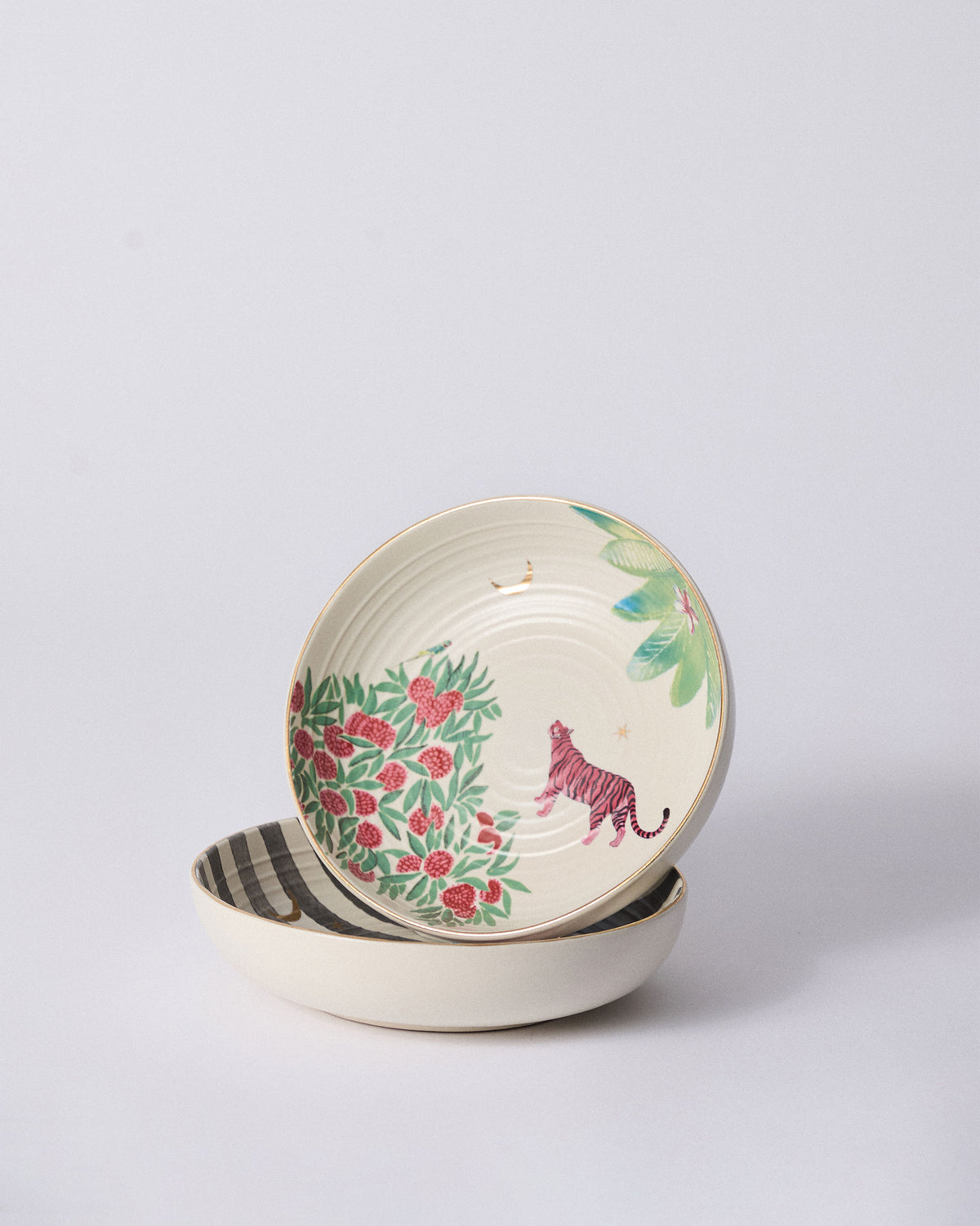 Stacked Ceylon Trail Shallow Bowls showing a pink tiger and striped rim.