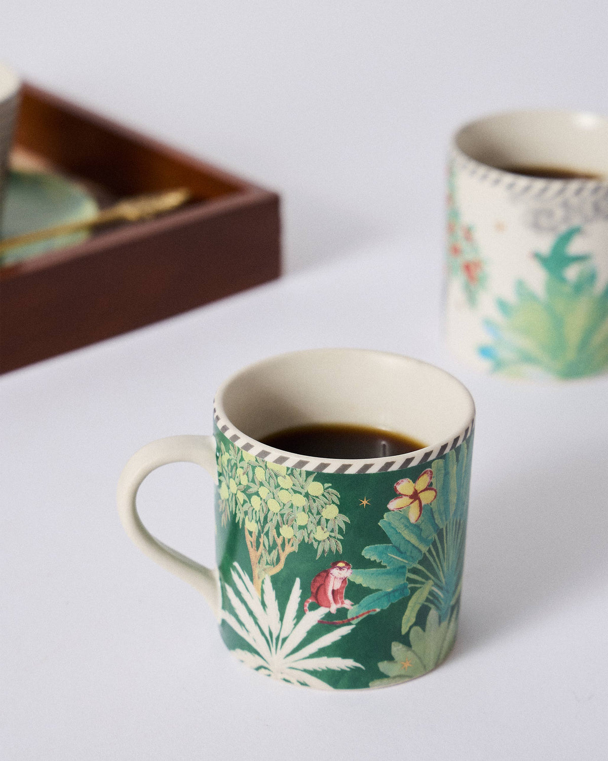 Ceylon Trail Straight Mug from the opposite side with palm trees and a yellow flower.
