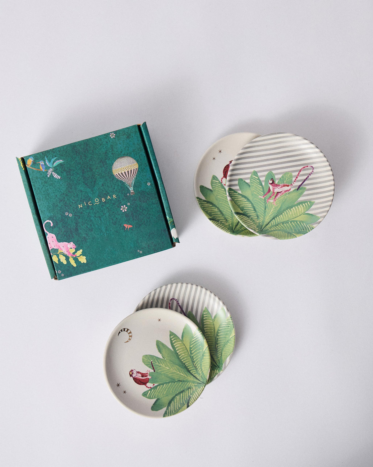 Ceylon Trail tea plate set of four beside a teal illustrated Nicobar gift box.