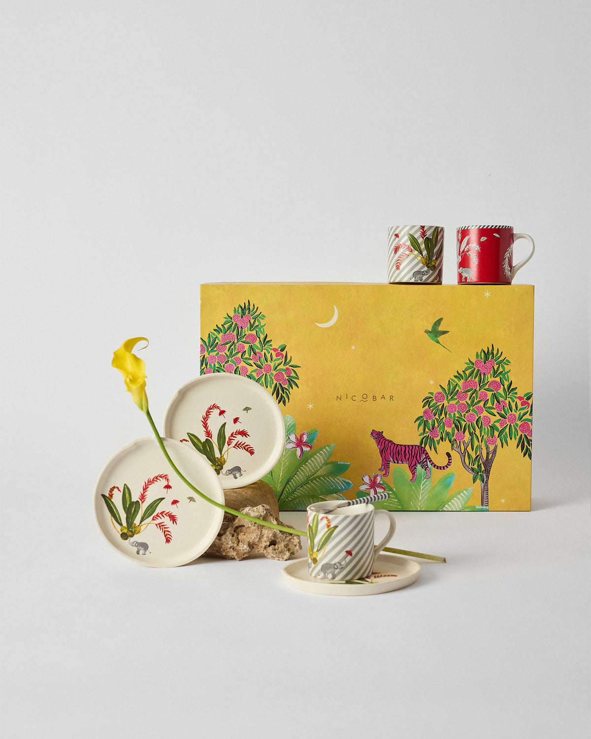 Thazin Trail Gift Set plates, cup and mugs in front of its yellow box with a tiger motif.