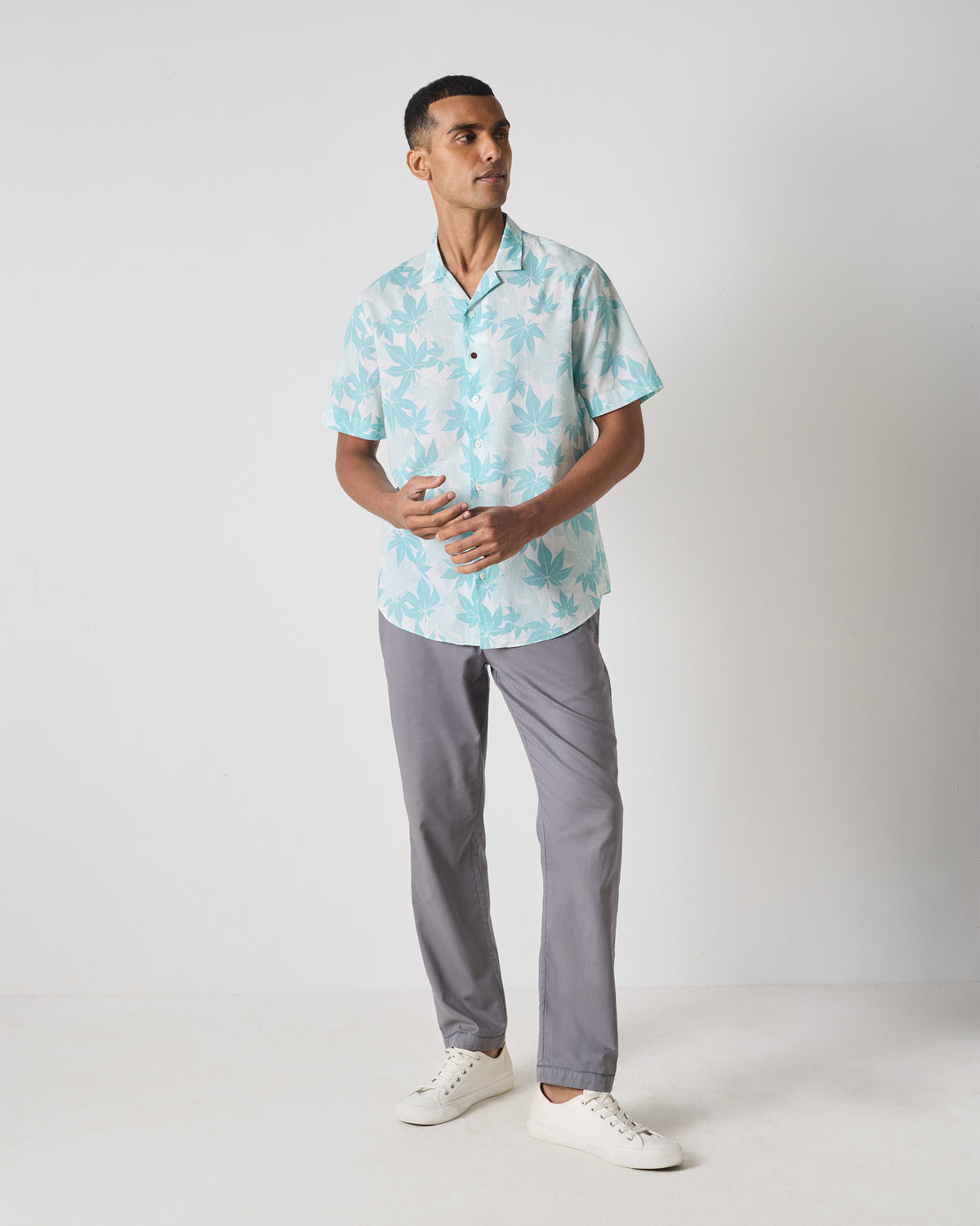 Person wearing a light blue Mistari shirt with an all-over leaf print.