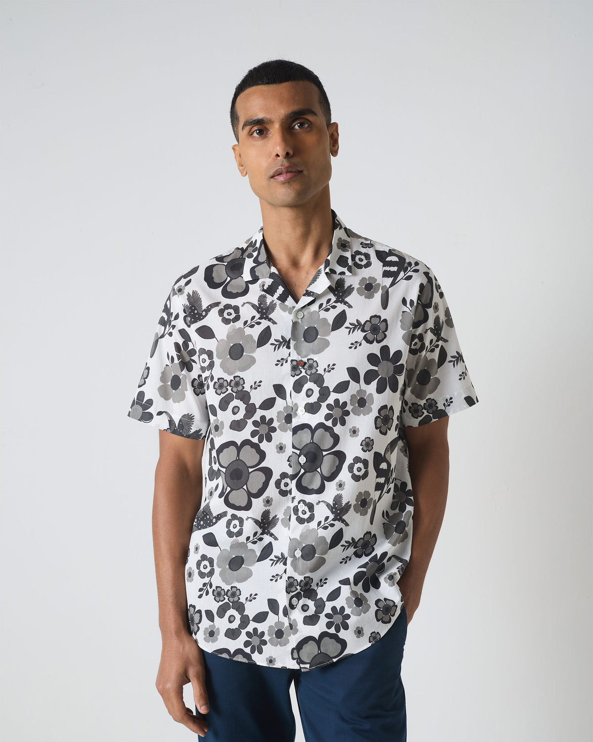 Person wearing a black and white Mistari shirt with a bird and flower print.
