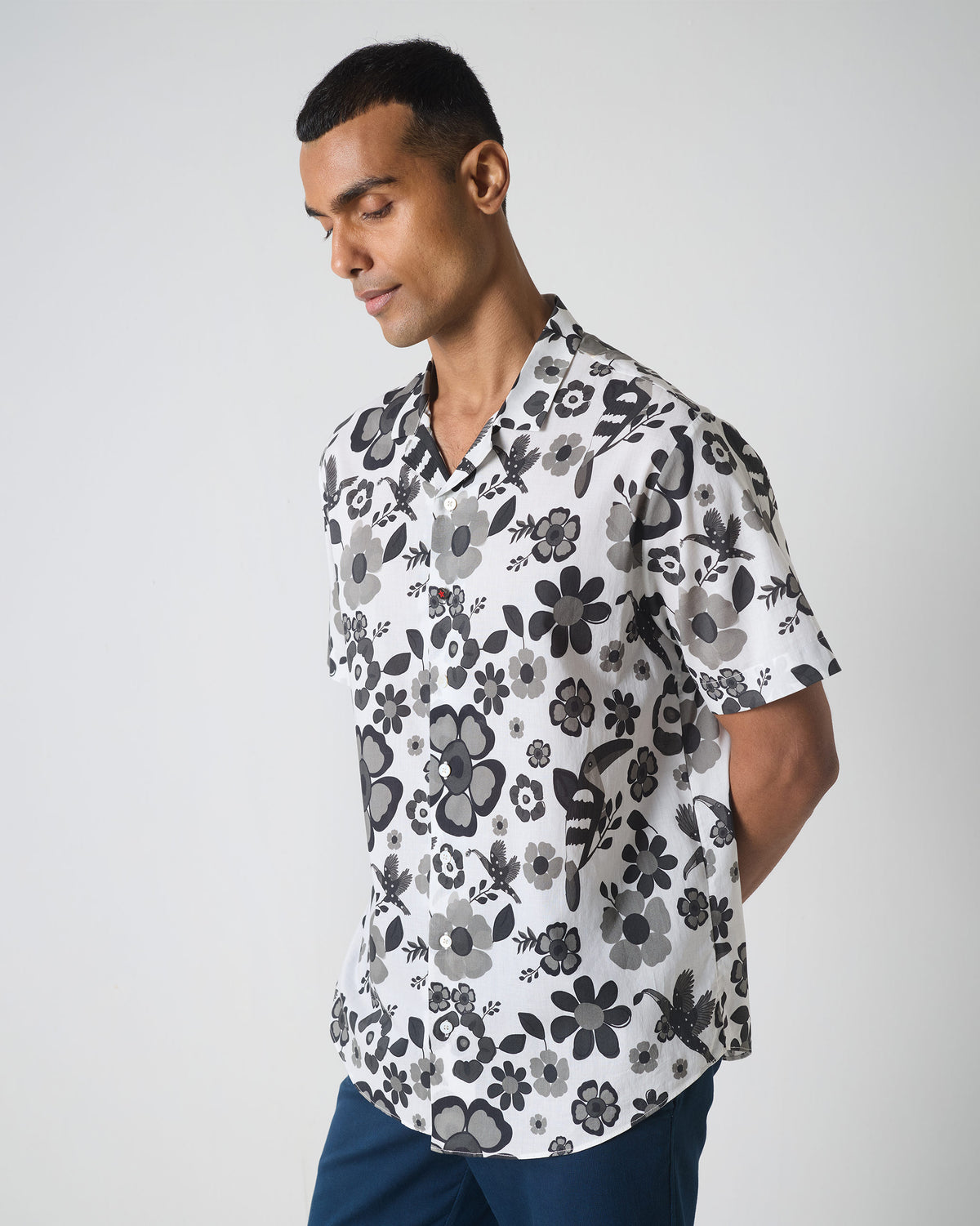 Three-quarter view of a black and white Mistari shirt with a floral bird print.