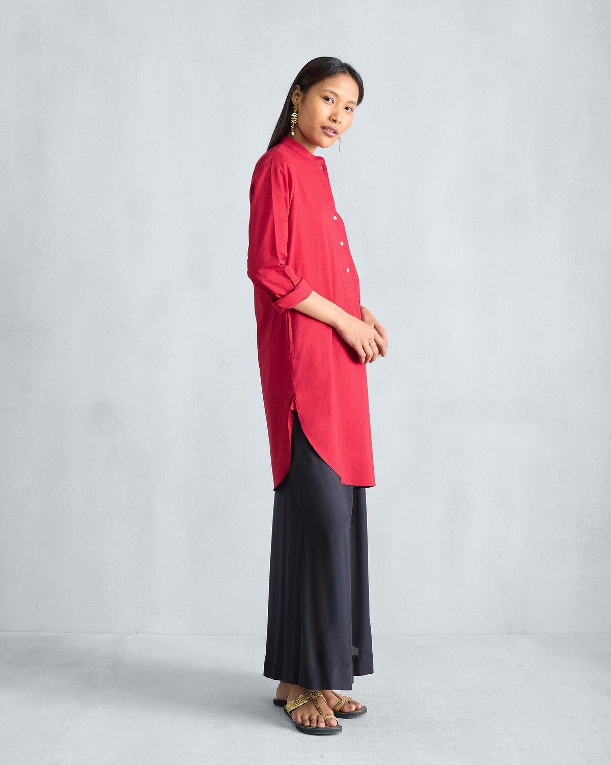 Side view of a red mid-length kurta with side slits.
