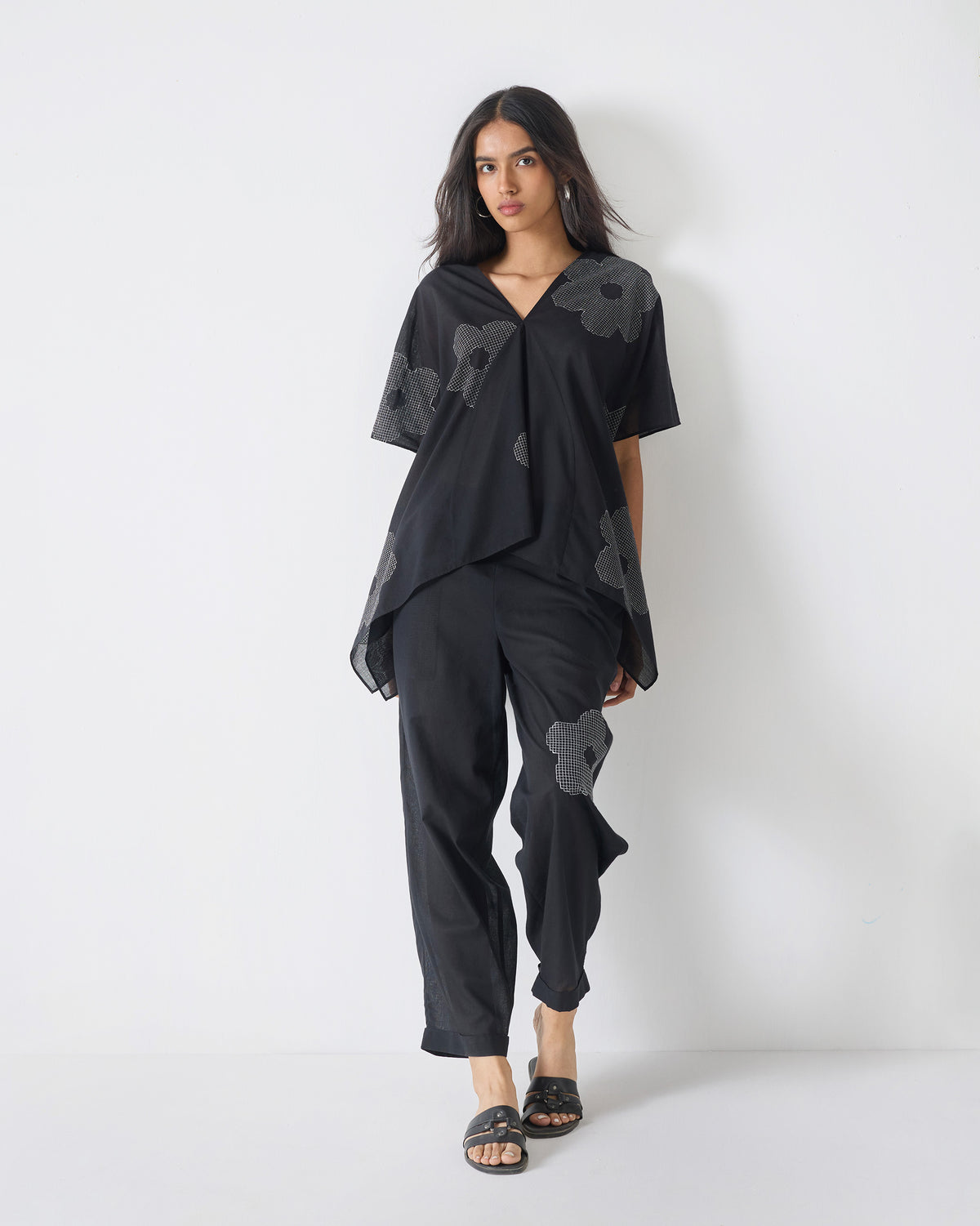 Black Curved Hem Top with white flower embroidery worn full length.