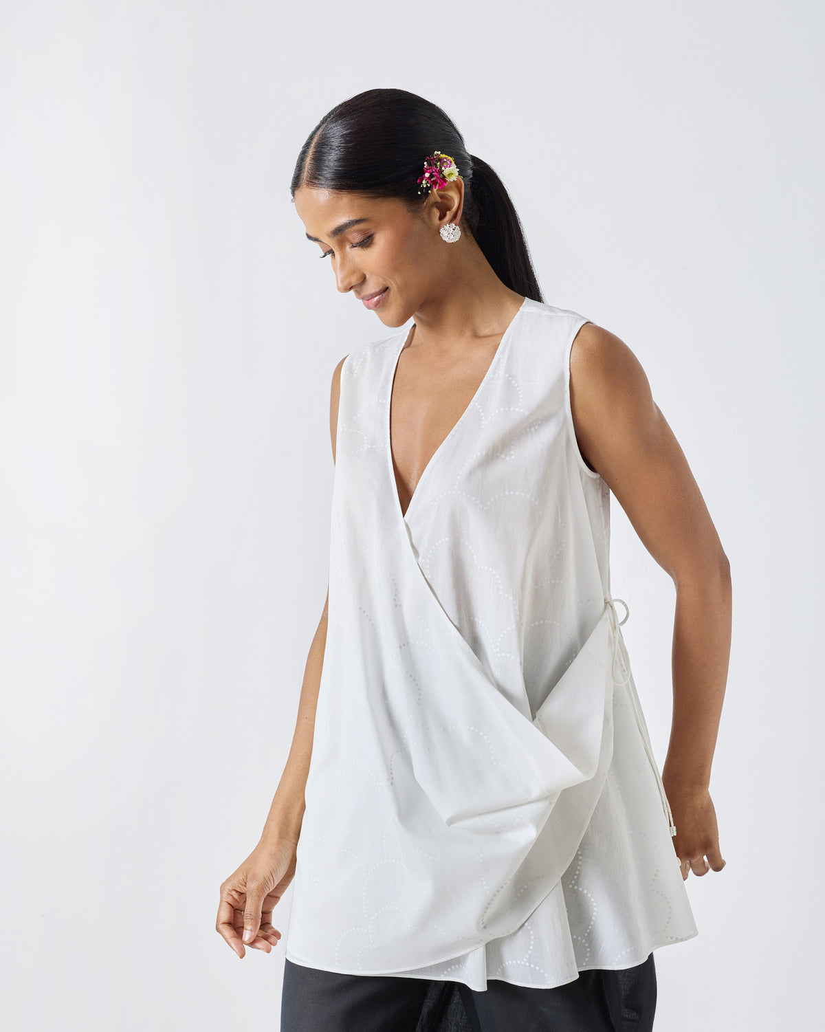 Person wearing a white Ren top with a sleeveless wrap front.