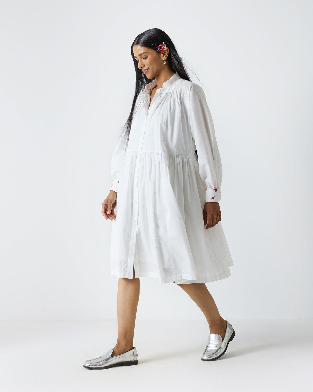 Side view of a white Miya button-front dress with a gathered skirt.