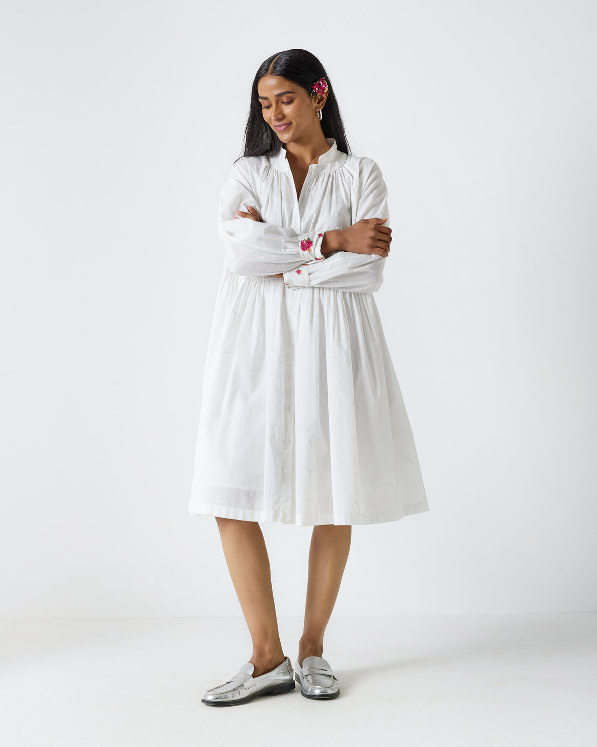 Person wearing a white Miya button-front dress with embroidered cuffs.