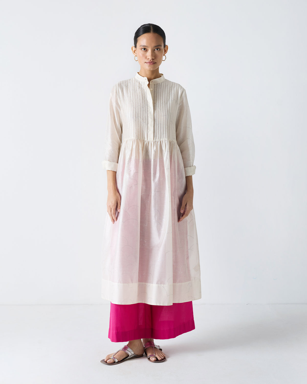 Person wearing an ivory Crescent Pintuck Kurta with a gathered flared skirt.