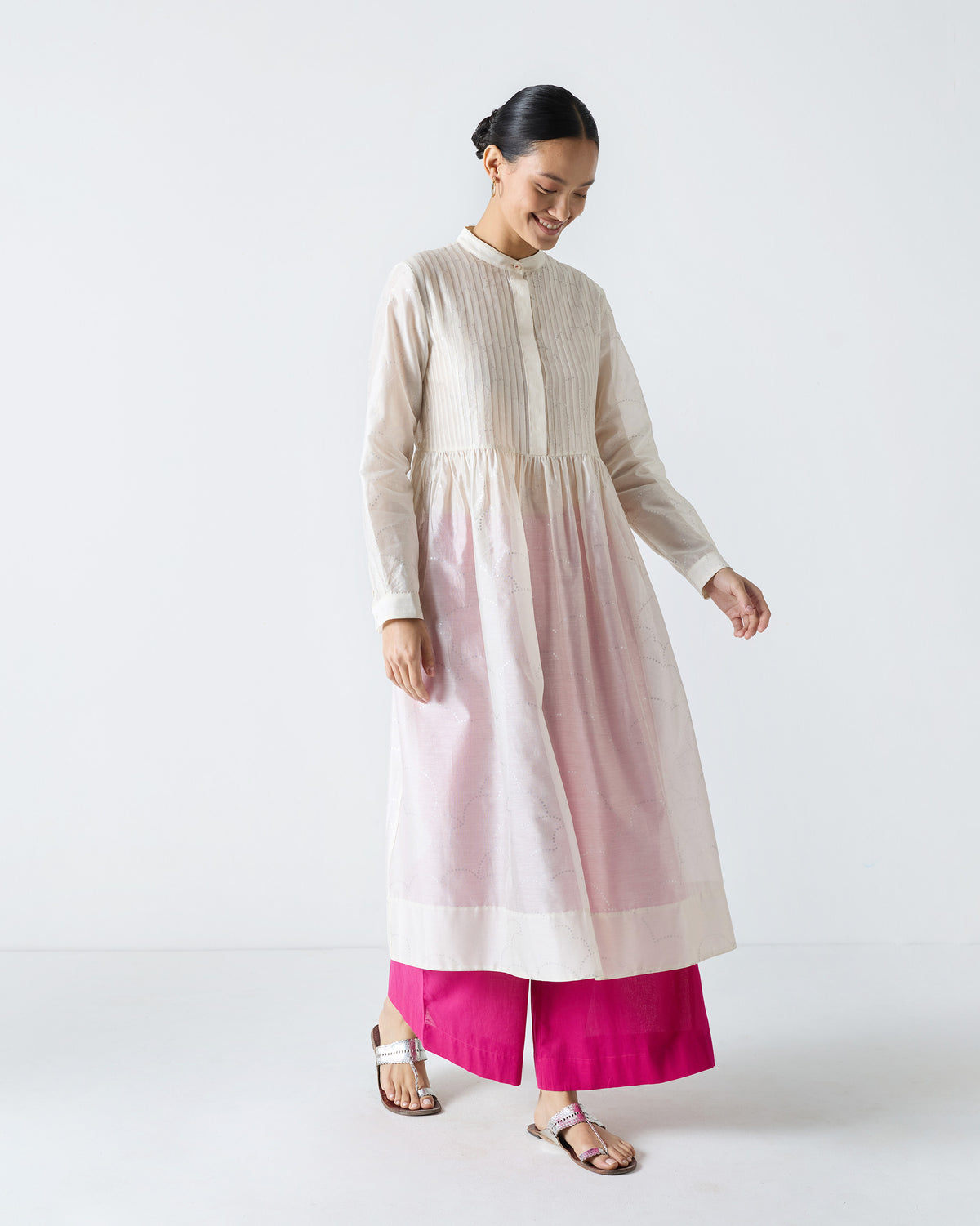 Person wearing an ivory Crescent Pintuck Kurta showing a flared mid-calf hem.