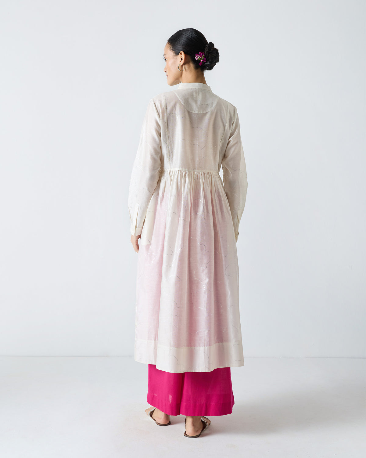 Back of an ivory Crescent Pintuck Kurta with a gathered waist and flared skirt.