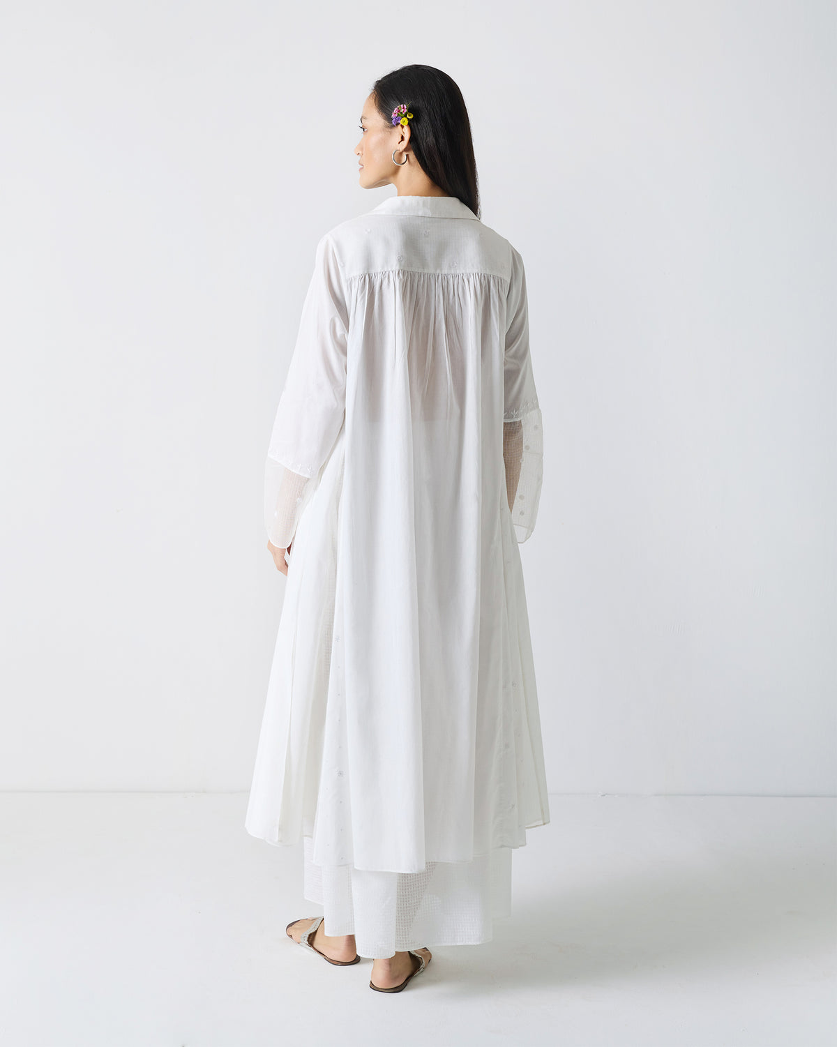 Back of a long white embroidered kurta with gathered yoke.