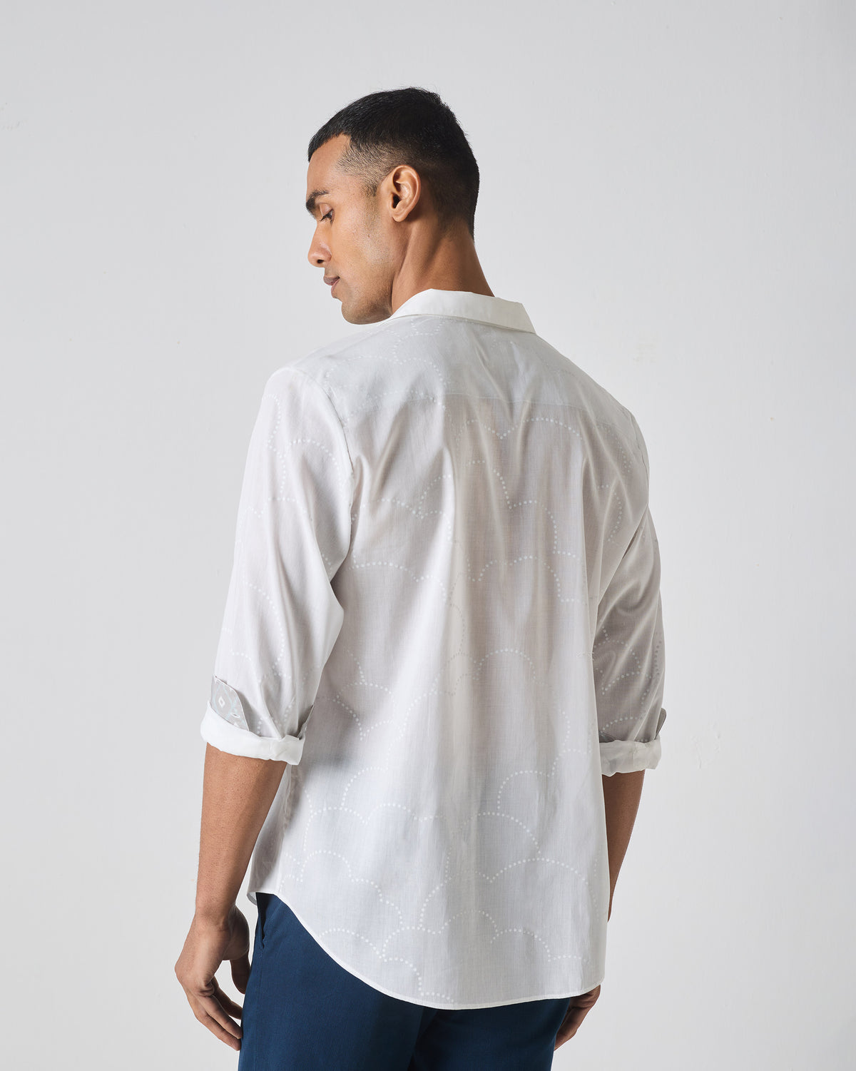 Back of a white Hakuna Shirt with tonal scalloped embroidery.