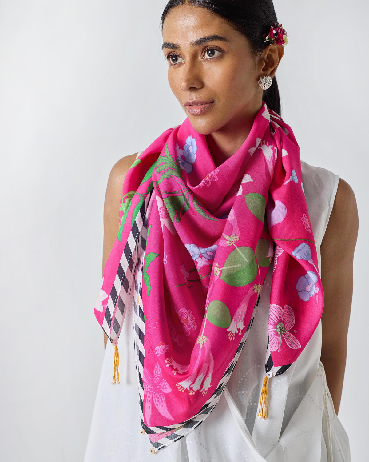 Person wearing a Wildflower Scarf in fuchsia with a black and white striped border.