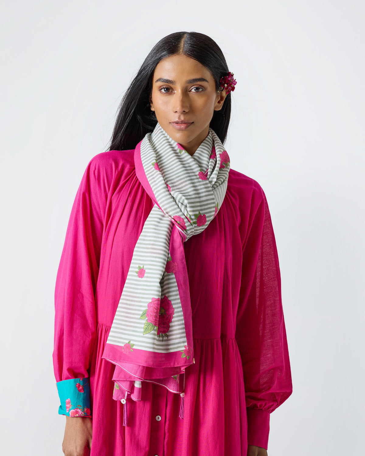 Person wearing a Stripes and Flowers Scarf in grey and white stripes with pink roses.