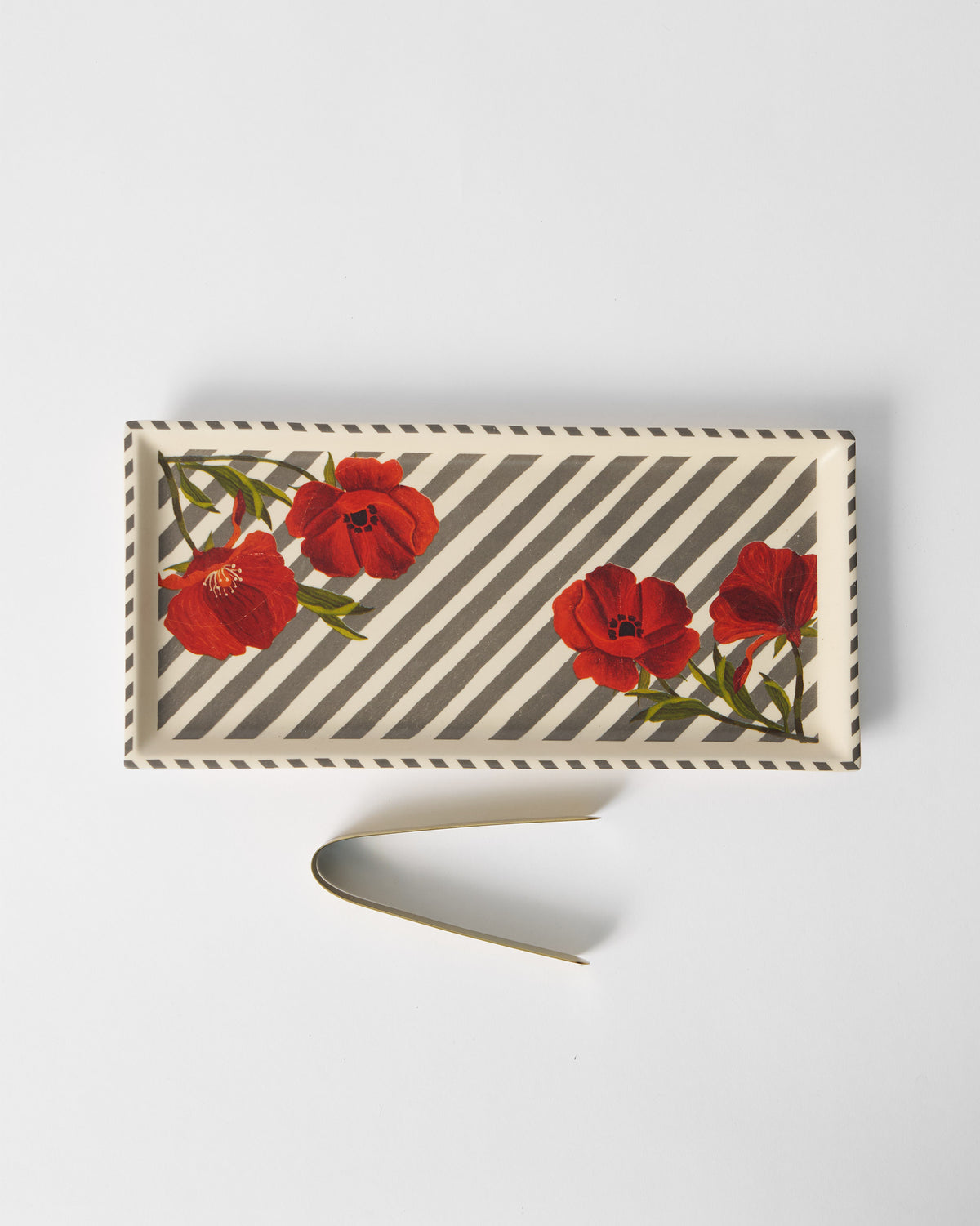 Striped Poppy cookie tray with red poppies and gold tongs laid beside it.