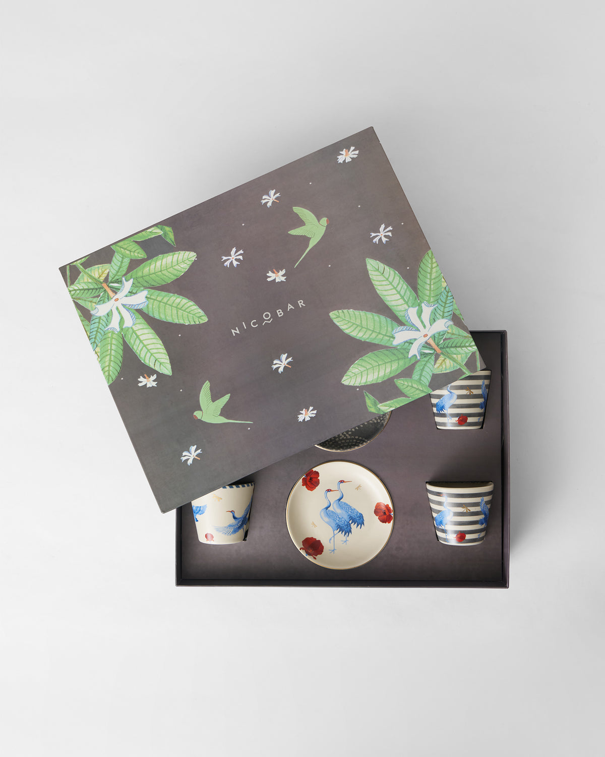 Open Dancing Crane gift box with crane plates and striped cups in a foam insert.