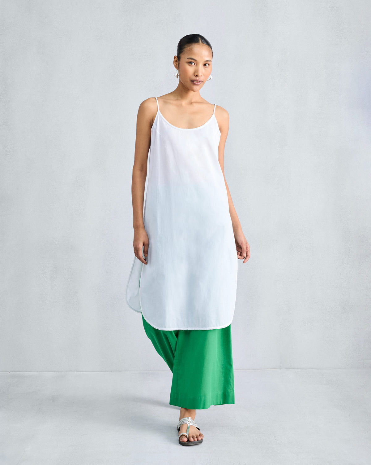 Person wearing a long white Vintage Camisole with a curved hem.
