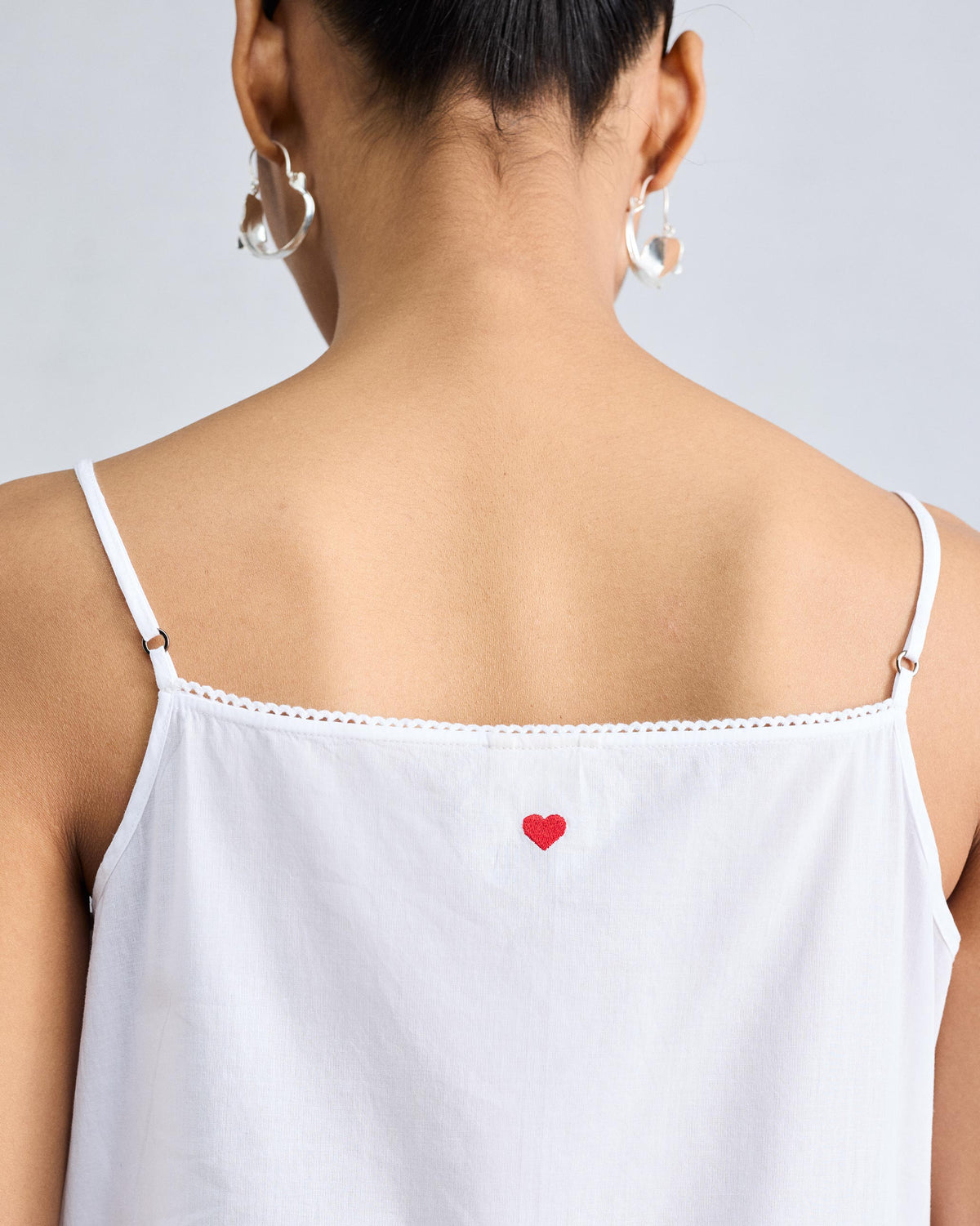 Close-up of a red heart on the back of a white Vintage Camisole.