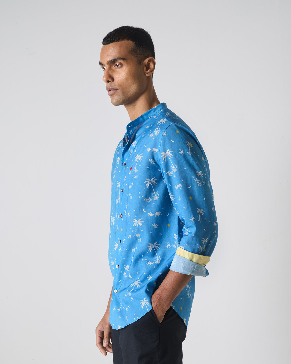 Side view of a blue Nawab shirt with white tropical print.