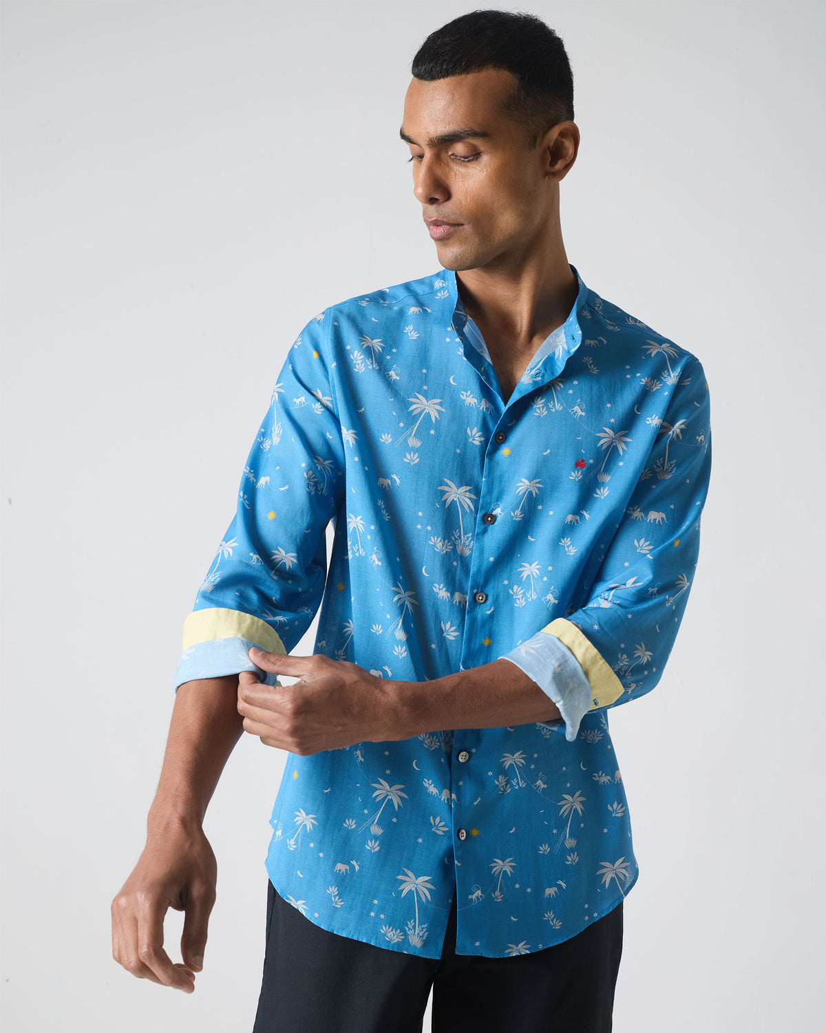 Person wearing a blue Nawab shirt with white tropical print.