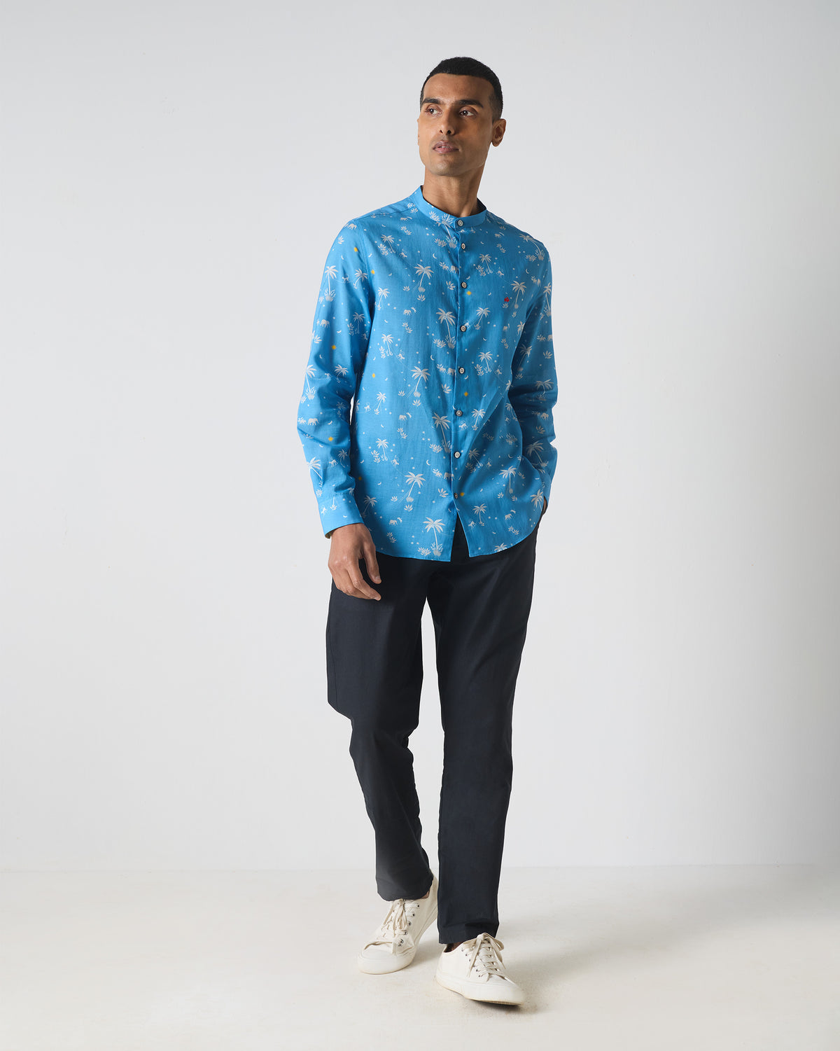Person wearing a blue Nawab shirt with white tropical print.